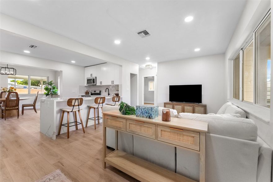 Fully renovated and move-in ready! This bright, open-concept home features a new kitchen with shaker cabinets, quartz countertops, stainless steel appliances, and a large peninsula with seating. Enjoy a seamless flow from the kitchen to the living and dining areas—perfect for entertaining. Modern finishes throughout include luxury vinyl flooring, updated lighting, and a stunning bathroom with a walk-in shower and illuminated mirror. The spacious covered patio overlooks a large fenced yard with a fire pit and with plenty of room for a pool. New roof, impact windows, and updated systems add peace of mind. Conveniently located near shops, schools, restaurants, and major highways!