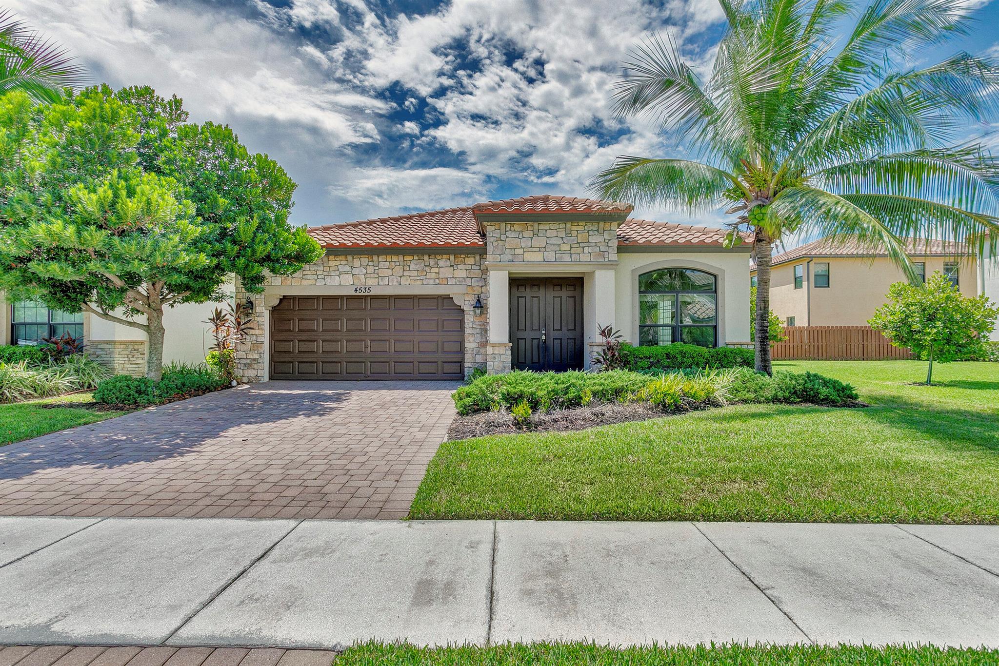 Fabulous single-story home in a gated, family-friendly community! Perfectly located near Wellington Green Mall, fine dining, and with quick access to Florida's Turnpike. Zoned for excellent schools, this residence offers both convenience and lifestyle. Step inside to soaring 9-foot ceilings in the spacious Living and Family Room areas. The light and bright kitchen is designed for both function and style, seamless connection to the covered terrace--ideal for indoor-outdoor living. The primary Suite is a true retreat, complete with a vast walk-in closet and a bath with a Roman tub and dual vanities. Light-filled interiors create a warm, airy atmosphere throughout, while maintaining a cozy feel. Community pool and playground. HOA requires min Credit 720 for all occupants over age 18.