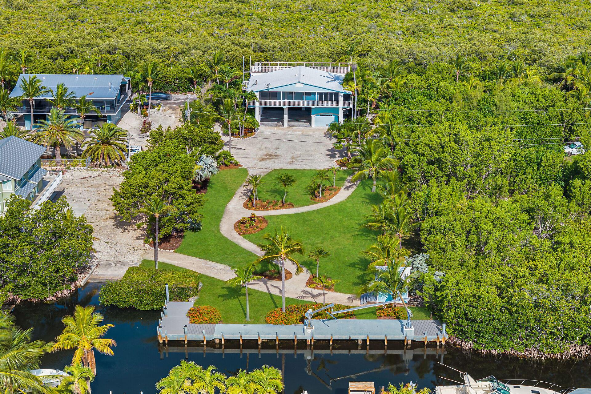 Welcome to Paradise! this home sits on almost 3/4 of an acre along a direct access canal with 100 ft of waterfront, a turning basin and neighborhood only boat ramp with no HOA! Want to park your RV and Boat under your home, done! Want to build your own luxury oasis, here you go. Want to just enjoy easy access to open water and majestic Sunsets from your private observation deck, got that covered! Fully screened wrap around porches allow you to open up and let the East - West trade winds breeze right through the entire home. Professionally landscaped perfection from your private dock with davits, boathouse and garden paths to the exterior elevator and massive shop/storage area downstairs. Close to Adams Cut. 1 hour from Miami international airport yet in the otherworldly Florida Keys