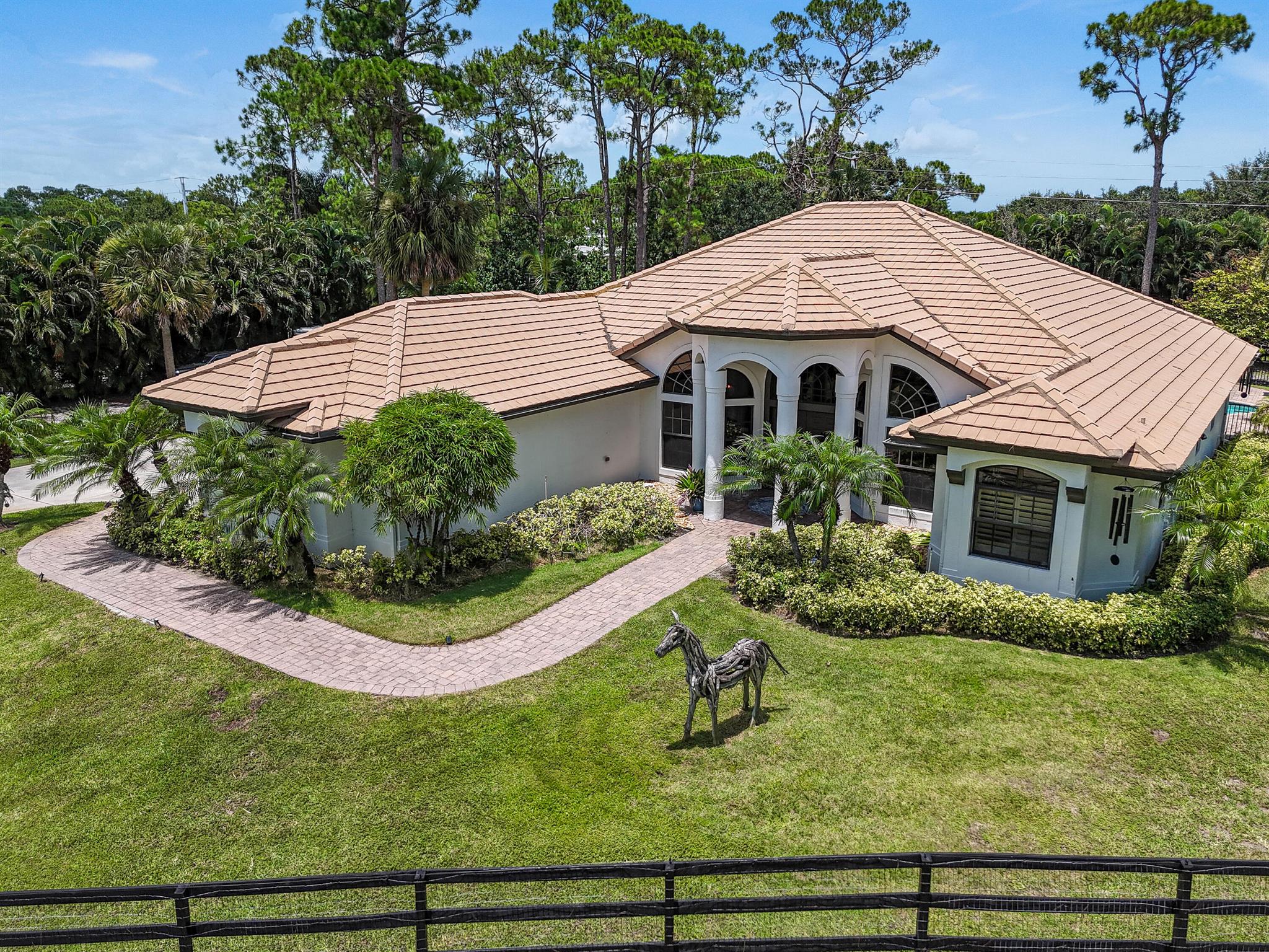 This remarkable 4/3 with den/office pool home is situated on 2+ private acres. As you enter the home, you will be greeted by a large Entry Foyer with high vaulted ceilings. The home features hurricane impact windows and doors throughout. The updated gourmet kitchen boasts high end appliances from Wolf/Sub-Zero and granite countertops. The backyard offers a tropical oasis with a large pool, sun/party deck, and screened-in patio. This is a secure, gated, and equestrian friendly community. The property has a 2-stall stable with tack/feed room, and a large fenced in area for grazing/turnout. The community also offers a park with playground, horse trails, picnic area, and boat ramp for a small boat. Golf membership at the Cape Club Golf Club is also available.