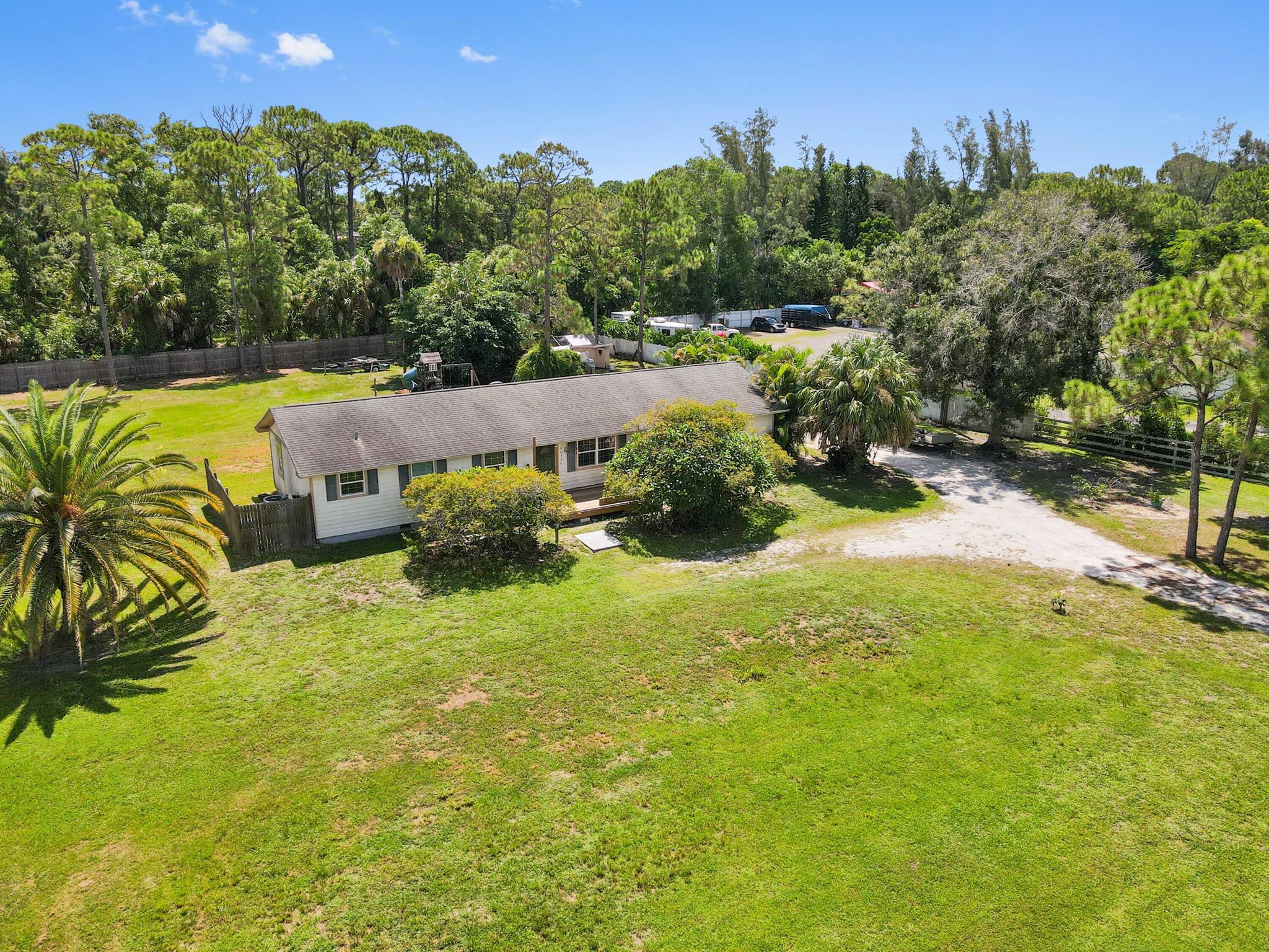Discover your piece of paradise in this light, bright, and charming 3-bedroom, 2-bathroom home, perfectly situated on a massive, oversized 1.25 acre lot on a quiet street. This non-HOA community gem offers unparalleled privacy, with a canal running along the entire east side of the property. The home features two wonderful decks, one at the front entry for a welcoming first impression and another in the back that provides a serene space overlooking the expansive yard. Inside, the living area boasts a vaulted ceiling and elegant vinly flooring, while French doors seamlessly connect the indoor space to the beautiful outdoors.