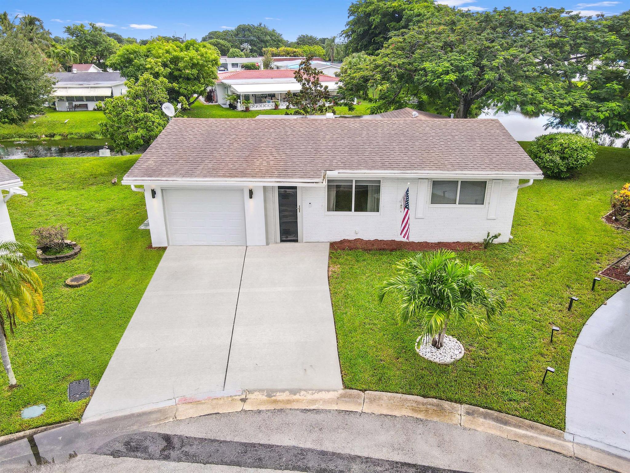 Welcome to this beautifully upgraded 1-story home in the desirable Paradise Gardens 55+ community. Nestled on a quiet cul-de-sac, this property offers stunning water views and easy entry-level living with a spacious Florida room. Featuring 2 beds &1 bath, the home boasts a 1-car garage, a 2018 roof, and a host of recent improvements.Enjoy peace of mind with 2024 upgrades, including new windows, hurricane protection, and a refreshed landscape with tree replacement. In 2023, this home received even more modern touches, such as a new AC, flooring, refrigerator, kitchen appliances, ceiling fans, a driveway extension, and an upgraded main water line.Perfect for those seeking comfort, security, and modern living in a tranquil setting! Don't miss the chance to make this your own!