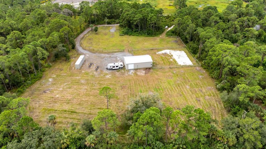 Here is a great opportunity to build on 5 well-maintained and improved acres in Martin county. The property is fully fenced and wooded along the road for privacy, making it ideal for bringing your toys and animals. Need a place to store belongings or work on your equipment while building? This property includes a shipping container and a 30x50 metal building on a concrete slab equipped with water and electric. The center of the property is clear and open, allowing for more possibilities
