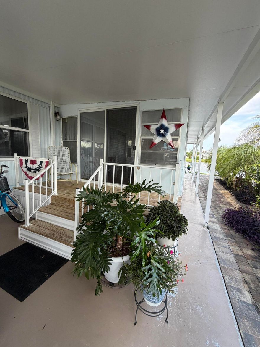 Oasis Village-55+ Community, Water view- Lake Okeechobee, Florida. This fully furnished, 2 bed 2 bath, split-bedrooms, SWMH on the water offers a serene lifestyle with a king bed in the master suite and private ensuite walk-in shower. tile and laminate floors throughout, while a new AC (2020) and metal roof (2017) ensure peace of mind. Recent upgrades include new appliances, tinted windows, a Florida room addition, and pavers surrounding the lush, private landscape. Enjoy a new back porch, a 2025 hot water heater, and hurricane shutters. Completely turnkey-just bring your suitcase and enjoy! Shopping and casino minutes away!