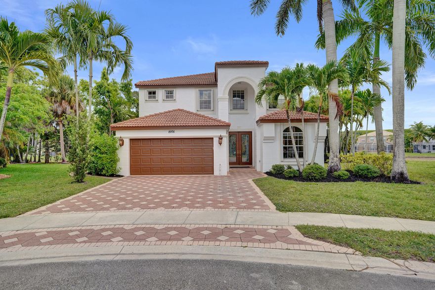 Tucked away at the end of a quiet cul-de-sac and surrounded by shimmering water and nature, this extraordinary waterfront residence offers a rare blend of privacy, elegance, and atmosphere within Olympia's prestigious gated community. From the moment you arrive, the home feels like an escape, a place where Florida sunshine meets European romance and everyday living feels beautifully elevated. Spanning over 3,600 square feet, this five-bedroom, 2.5-bath home, plus a den or office, is defined by its soft pastel palette, soaring ceilings, and sparkling crystal chandeliers that bring a sense of old-world charm and playful sophistication to every space. Natural light pours in from all angles, highlighting thoughtful architectural details and creating interiors that feel whimsical, warm, and every space. Natural light pours in from all angles, highlighting thoughtful architectural details and creating interiors that feel whimsical, warm, and irresistibly inviting. The mood is unmistakable, less suburban South Florida and more Italian villa by the water. The heart of the home is a spacious open kitchen, designed for both effortless entertaining and everyday enjoyment. A large center island, striking cabinetry, a wine cooler, and seamless connection to the living areas make it ideal for gatherings both intimate and grand. Nearly 180-degree lake views provide a dramatic, ever-changing backdrop, turning meals and moments into experiences. The primary suite is a true retreat, generously sized and thoughtfully designed with custom bathroom finishes and a private terrace overlooking the pool and expansive lake. Mornings begin with sunlight dancing across the water, and evenings end with the sky painted in color, a setting that feels straight out of the Italian countryside. Outdoors, the home transforms into a private resort. A brand new screened-in patio, adorned with cafe lighting, creates an enchanting space for long dinners, sunset aperitivos, and relaxed evenings under the stars. The pool and spa overlook the lake, capturing breathtaking sunset views that reflect across the water and fill the oversized backyard with quiet, cinematic beauty. Lush landscaping enhances the sense of seclusion, making the outdoor living areas feel intimate, serene, and intentionally designed. Living in Olympia means enjoying resort-style amenities while being perfectly positioned in the heart of Wellington, a community celebrated worldwide for its polo fields, equestrian estates, and international show grounds. This is a place where horses, heritage, and refinement shape the lifestyle, yet shopping, dining, and everyday conveniences are just minutes away. And when the mood shifts toward salt air and ocean breezes, the beach is an easy drive, making coastal days effortlessly accessible. Here, you enjoy the very best of Florida living, sunshine, water, and seamless indoor-outdoor flow, with the rare sensation of being transported somewhere entirely different. It is a home that feels collected, not copied. Romantic, not routine. This is more than a residence. It is a waterfront sanctuary that radiates serenity, exclusivity, and soul, a place that lingers in memory long after the doors close behind you.