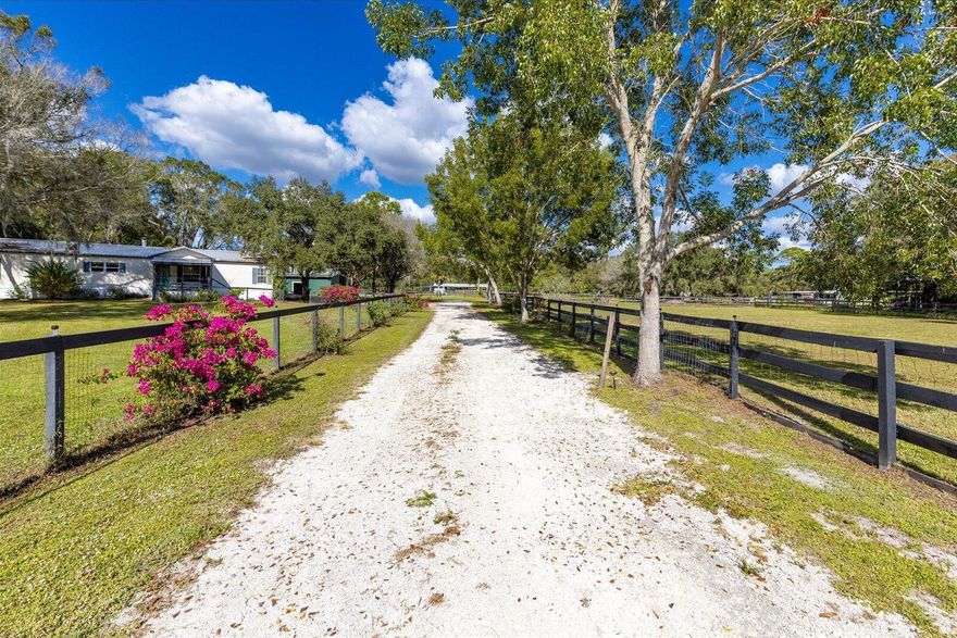 This one-of-a-kind unique oasis with SO many distinct features will leave you breathless!  The home is 3 bedrooms & 2 bathrooms, split plan style.  Great for entertaining with a fabulous fireplace.  Front barn offers 3 stalls, tack room with a feed room.  Back barn has 5 paddocks & all have turnouts.  Perks include cross fencing, a Koi pond once used for meditation, or you can simply enjoy the tranquility.  Plus, a dog run!  Completely fenced in as well as the ENTIRE property that is over 4 acres!  Newer metal roof, water heater & A/C ductwork & also has a generator & water filtration.   Horses, ponies, donkeys, chickens, cats & dogs are all welcome!