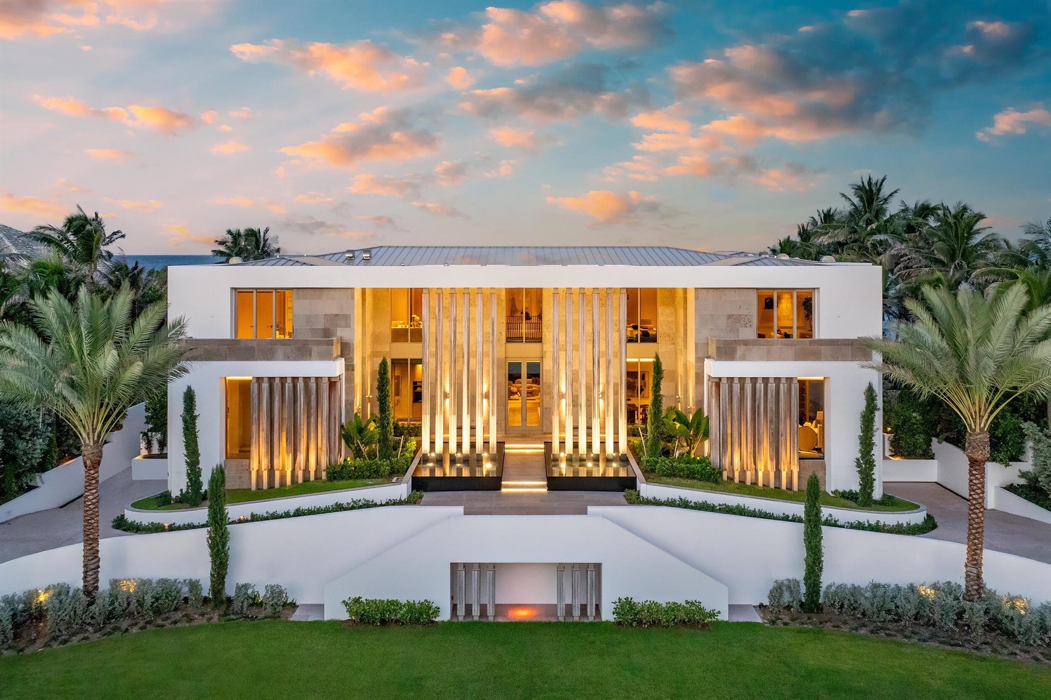 This exceptional 2024-built modern estate sets a new benchmark for luxury living in the exclusive community of Manalapan. Encompassing more than 25,500 square feet on a remarkable 1.5-acre double-frontage lot, the residence offers 172 feet of direct frontage on both the Atlantic Ocean and the Intracoastal Waterway. A private 50-foot dock with boat lift, dual jet ski lifts, and mooring piles provides effortless water access.A grand double-height foyer with cascading water features creates an unforgettable first impression. The open, light-filled interior showcases sweeping ocean views and an elegant blend of contemporary design and coastal refinement. Finishes include limestone slab flooring, wide-plank oak, and expansive walls of glass that elevate the interior with warmth and