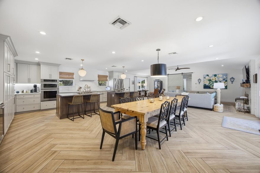 This is your rare opportunity to own a beautifully updated 6-bedroom, 3.5-bath home situated on a dry 1-acre lot in the heart of Jupiter Farms, located off paved Alexander Run. Offering 3,000 square feet of living space, this home was thoughtfully designed with both comfort and entertaining in mind.  The main living areas are flooded with natural light and showcase beautiful herringbone-style wood-look tile flooring throughout the expansive open-concept layout. The living room, dining area, and newly renovated kitchen seamlessly flow together beneath vaulted ceilings, creating a bright and welcoming atmosphere that feels both spacious and inviting.  The kitchen truly serves as the centerpiece of the home, featuring double islands, a single oven, double dishwashers, a built-in wine bar,  abundant cabinetry, and an extended gathering area perfect for entertaining. The open flow throughout the home creates a warm yet functional feel that captures the relaxed lifestyle Jupiter Farms is known for. Additional features include a whole-house reverse osmosis water filtration system and indoor laundry.  This home features six bedrooms along with two beautifully updated guest bathrooms. The oversized primary suite is a true retreat offering generous proportions, beautiful natural light, a large walk-in closet with charming barn doors, and a stunning fully renovated bathroom complete with a large soaking tub, spacious shower, and elevated finishes that create a spa-like feel.  Step outside and enjoy the Florida lifestyle with a newer pool, expansive covered patio, cabana bath, and a backyard designed for entertaining, relaxing, and making the most of outdoor living. Whether you're envisioning room for boats, trailers, RVs, toys, gardens, or play areas, this property offers endless possibilities, including a 50-amp RV hookup already in place.  A rare combination of size, updates, functional living space, and usable acreage in one of Jupiter Farms' most sought-after paved road locations. Enjoy the privacy and space Jupiter Farms is known for while still being just minutes from beautiful beaches, dining, shopping, A-rated schools, golf courses, and easy access to I-95 and the Turnpike.