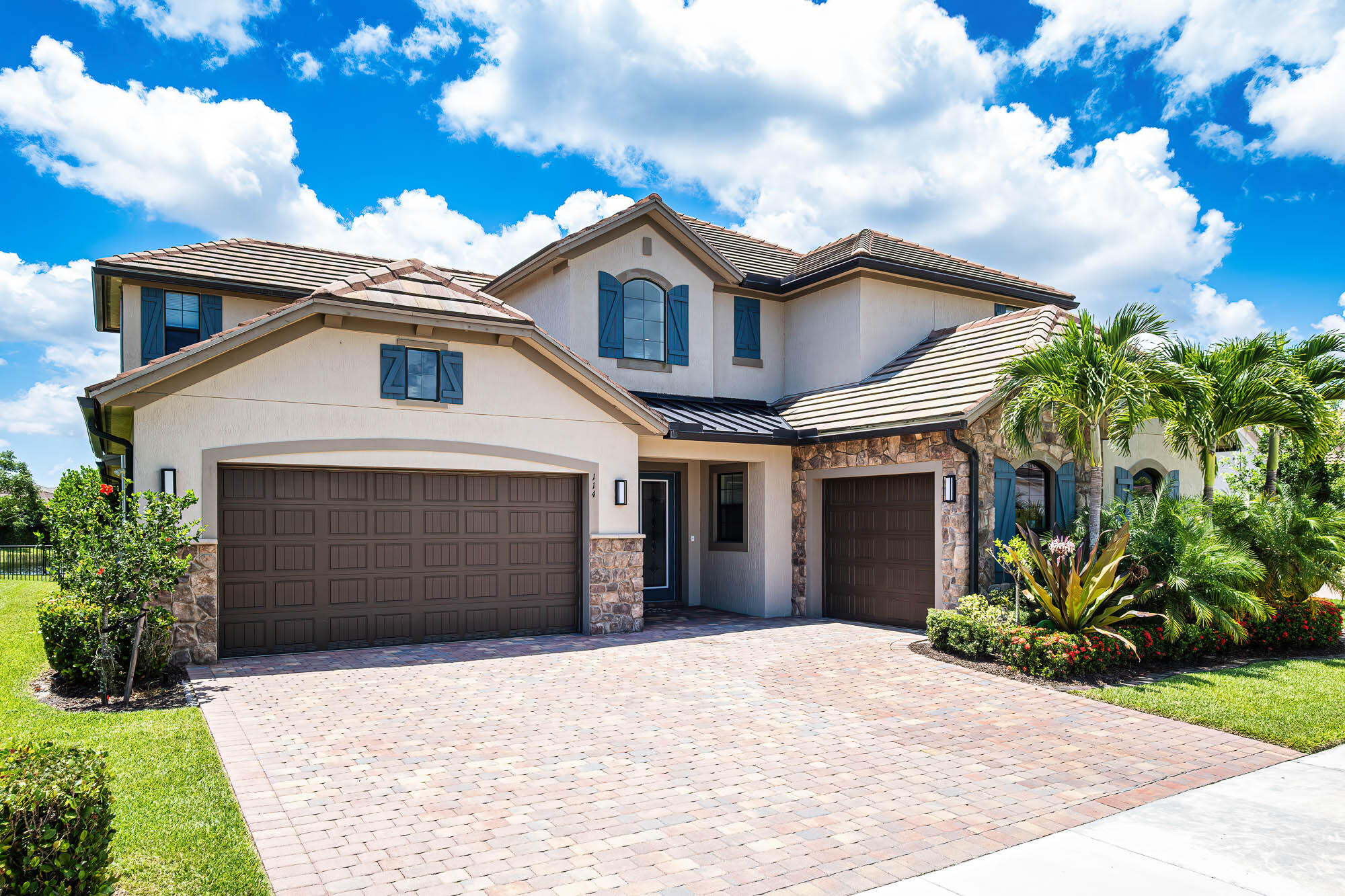 This lot was specifically selected for its highly desirable southern exposure and long lake view. The leaded glass doors of this exquisite 2-story home open to a stunning ornamental staircase and a spacious open floor plan filled with natural light. 5 bedrooms, and 5 1/2 baths. Perfect for generational families, the primary bedroom, guest room, and office/flex space are downstairs, plus 2-separate garages. Enjoy the relaxing, long lake view from your pool and spa. The rear impact glass sliding doors open completely, expanding the living space into the screened lanai. Positioned on the western side of the community, this home benefits from its distance from the FL Turnpike and I-95. This is a spectacular place to call home. Don't miss this opportunity--schedule your private showing today.
