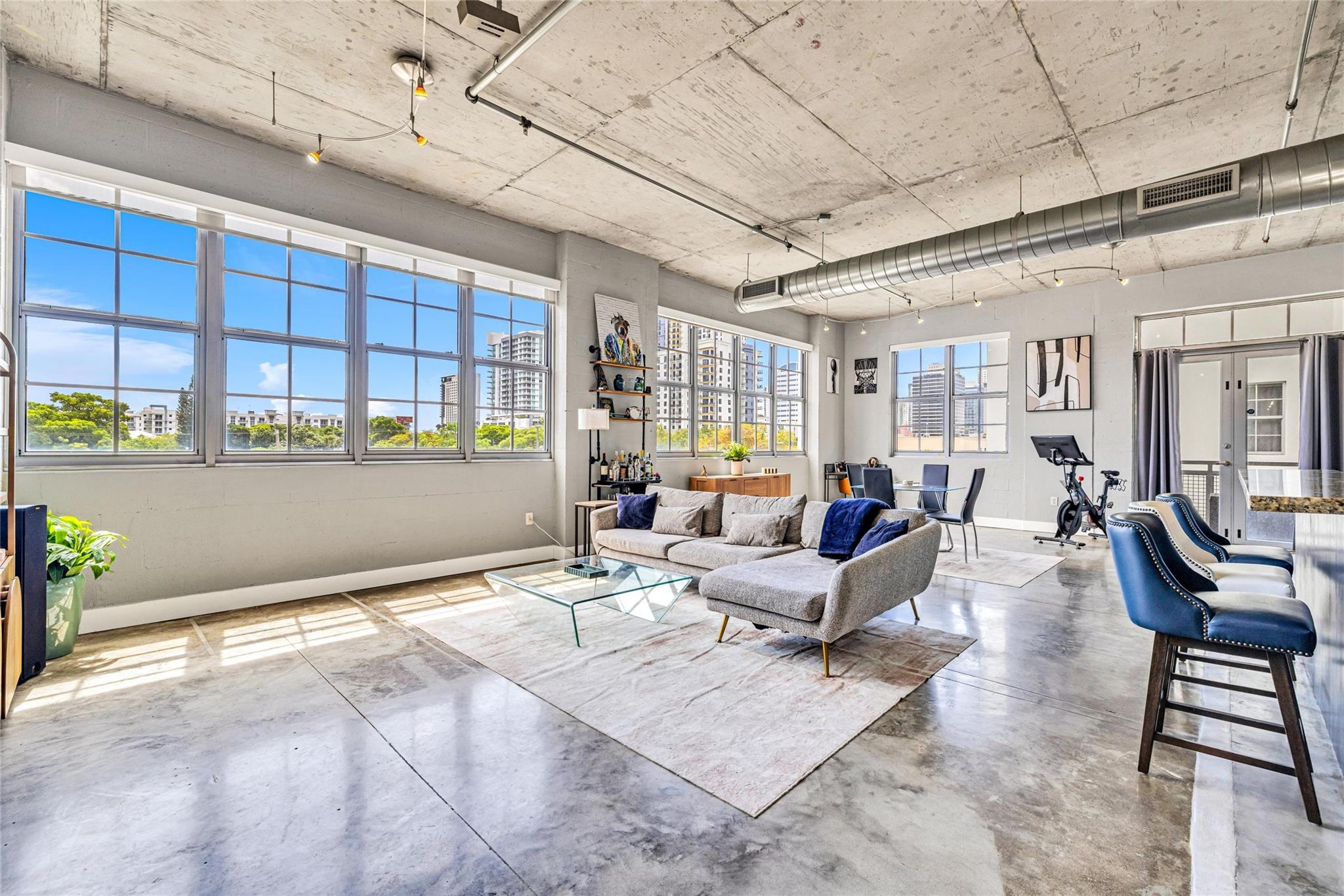Urban Chic 2 Bed/2 Bath Corner Loft in Flagler Village! This light-filled corner unit features soaring ceilings, concrete floors, exposed ductwork and concrete block walls - a true industrial feeling. Open floor plan with walls of windows offering abundant natural light. Pet-friendly (2 pets, no weight limit). Recent building exterior renovation/waterproofing project completed—all assessments paid. Building is fully compliant with 2025 safety requirements. Enjoy the renovated rooftop pool & fitness center with stunning skyline views. Prime location just 2 blocks from Brightline Station, 1 block from the exciting new FAT Village development (completion expected May 2026), Sistrunk Marketplace, shops, dining, and art galleries. Walkable, vibrant, and connected—urban living at its best.