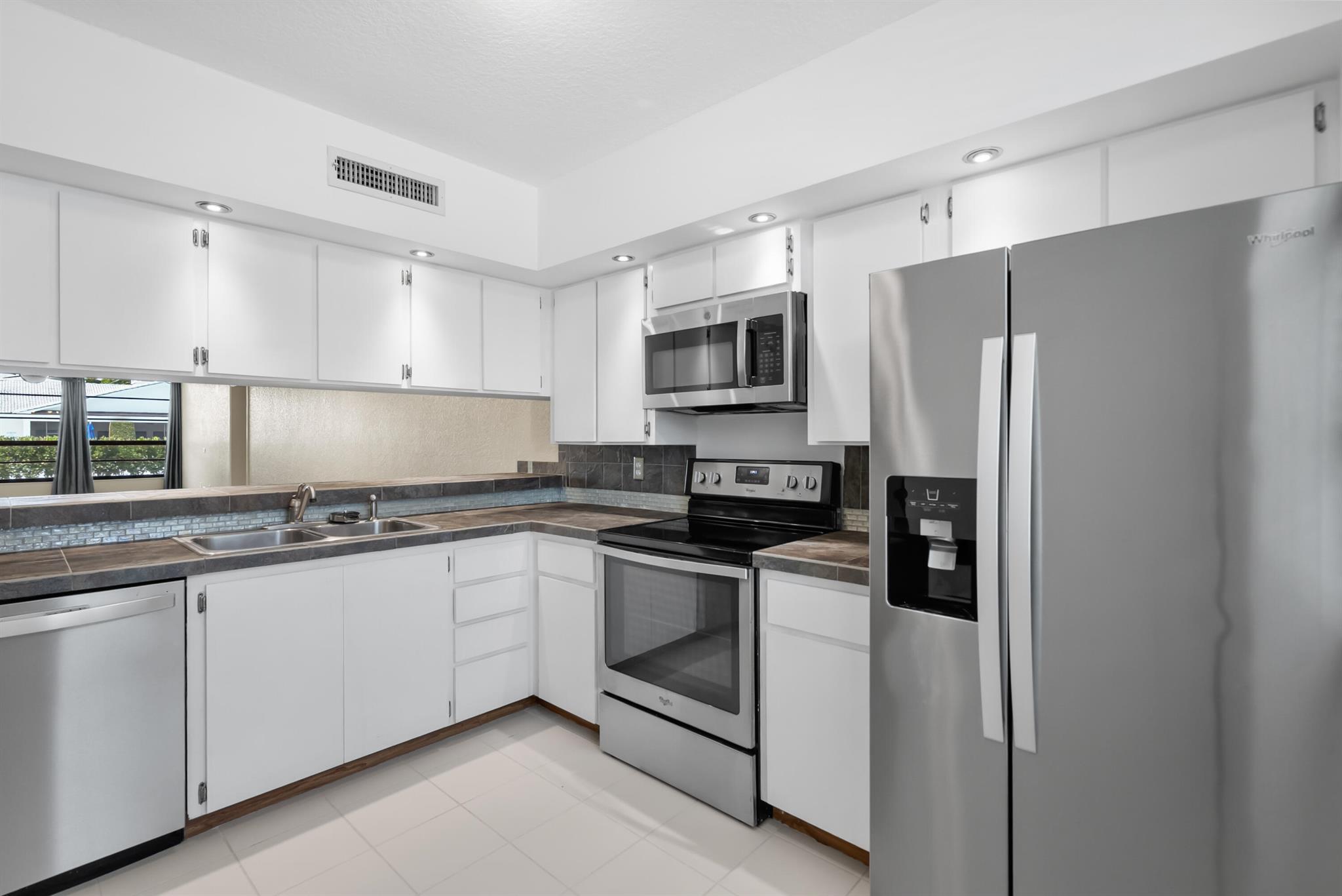 **Seller is offering up to $5,000 toward buyer contributions, presenting an excellent opportunity for qualified buyers!**Welcome to this inviting ground-floor 2 bedroom, 2 bath condo with a versatile den/office and convenient interior laundry room. The home has been freshly painted and features newer stainless steel appliances and hurricane impact windows for comfort and peace of mind. With plenty of guest parking and close proximity to the community pool and clubhouse, it's an ideal setting for both relaxation and everyday living. Perfect as a primary residence or seasonal retreat, this condo is well-maintained and move-in ready.