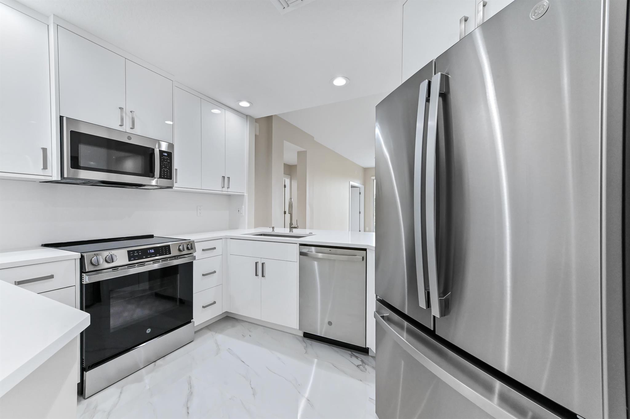Introducing a sophisticatedly updated residence at 12510 Crystal Pointe Dr #102, located in the vibrant heart of Boynton Beach, Florida. This stunning ground-floor unit elevates the standard of modern living, boasting a complete top-to-bottom renovation with luxurious finishes and state-of-the-art features. Step inside to discover a bright, open living space graced with porcelain tile flooring throughout, echoing the elegance of natural stone and infusing the home with an air of refined opulence. The living area seamlessly connects to the well-appointed kitchen and dining space, offering a versatile layout perfect for both tranquil living and entertaining.
