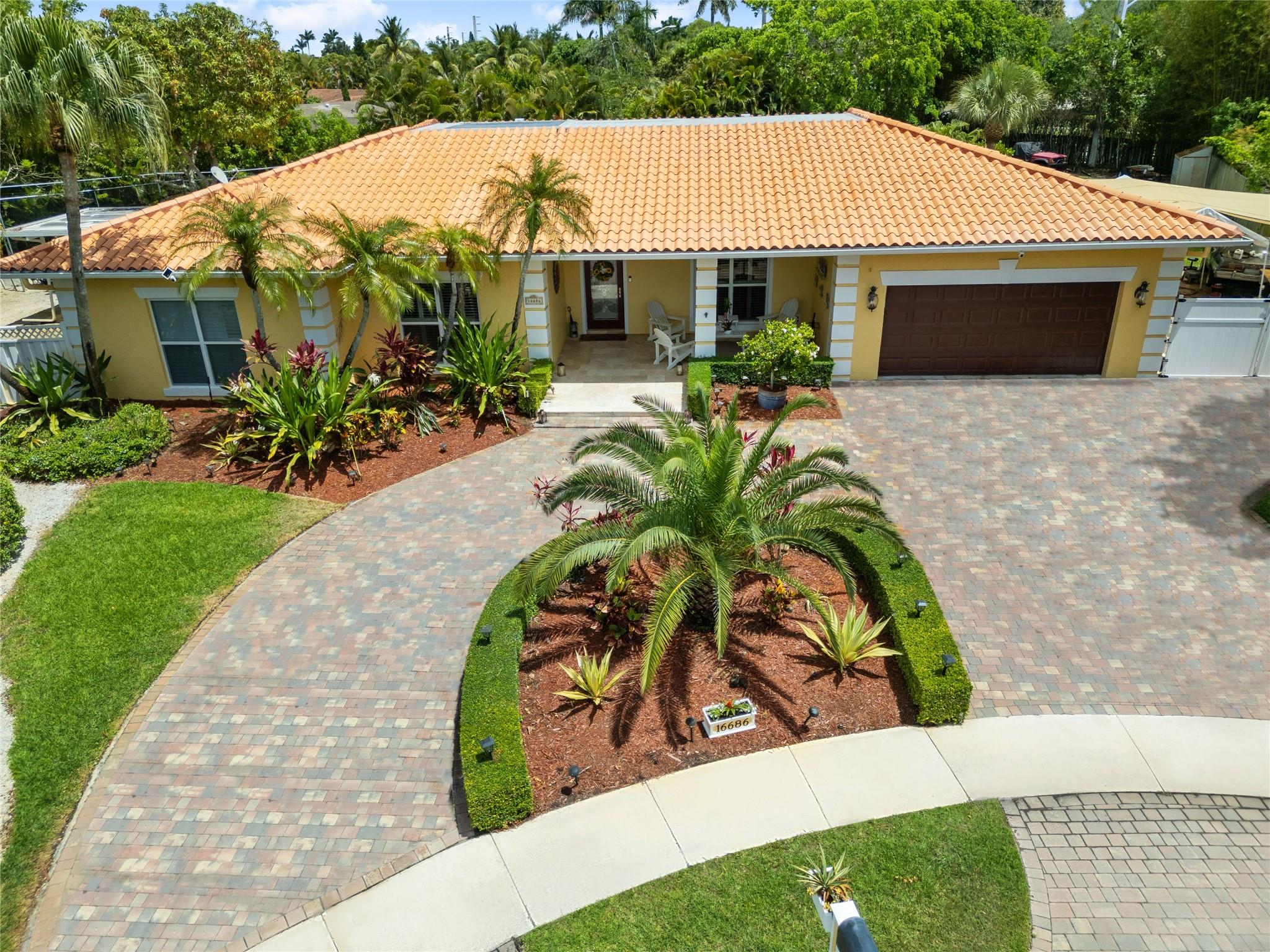Custom home completely updated 4 bd 3 bath plus office smart home nestled on rare ½-acre lot in the heart of Weston Impact windows & doors, marble & wood flooring gourmet kitchen boasts an oversized island, ss appliances, wood cabinetry, granite countertops, distinctive copper farmhouse sink. Large picture windows offer serene views of backyard oasis. The luxurious master suite incl a spa-like bathroom with a spacious jacuzzi tub, shower featuring body sprays and a rain showerhead. Enjoy seamless indoor-outdoor living with a spacious covered patio summer kitchen & expansive backyard, perfect for entertaining or relaxing. Extended patios & 2nd covered patio area w batting cage & rec area, workshop area, & enjoy the cul-de-sac from front patio, near top-rated schools parks HOA only 385 a yr