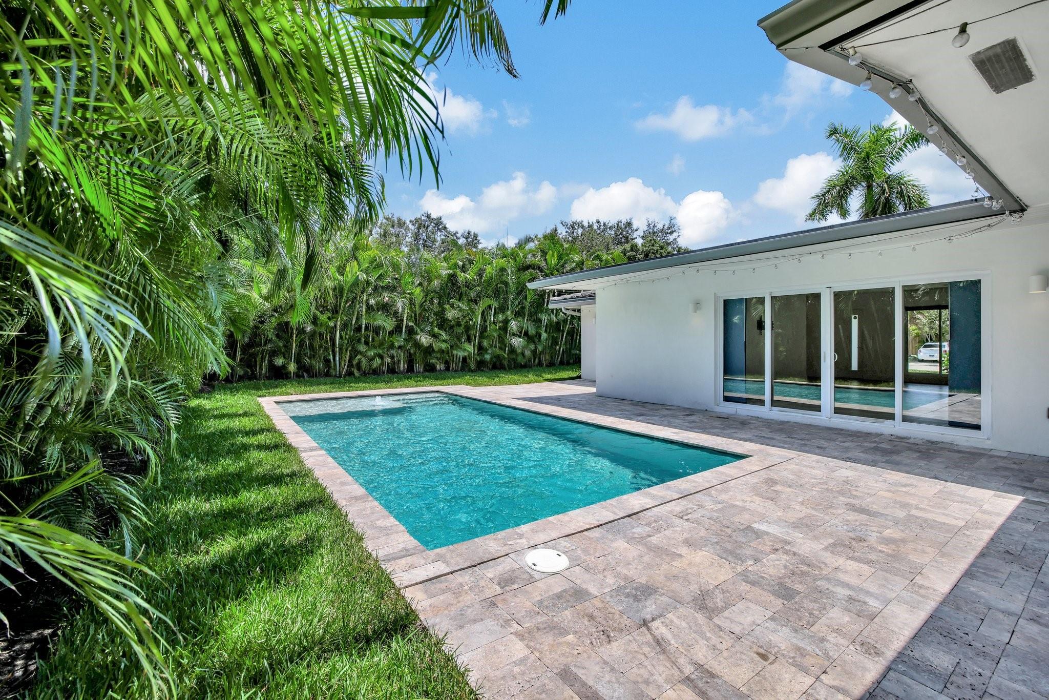 Annual or Short-Term Lease! This beautiful and modern pool home could be your tropical getaway in a fantastic location. It's just a short distance from the beach, restaurants, shops & more. This home features 3 bedrooms and 3 bathrooms, completely renovated in 2018, showcasing a bright and open layout with gorgeous white cabinetry, stainless steel appliances, and quartzite countertops in the kitchen. The primary suite is located on one side of the house, while the 2 guest bedrooms are on the other side. Additionally, you'll find luxury vinyl flooring and impact windows throughout and a hookup for an electric car charger in the 2-car garage. Relax in a private resort-style pool in the backyard. Lawn/landscape and pool maintenance are included in the rent. Call today for a private showing!