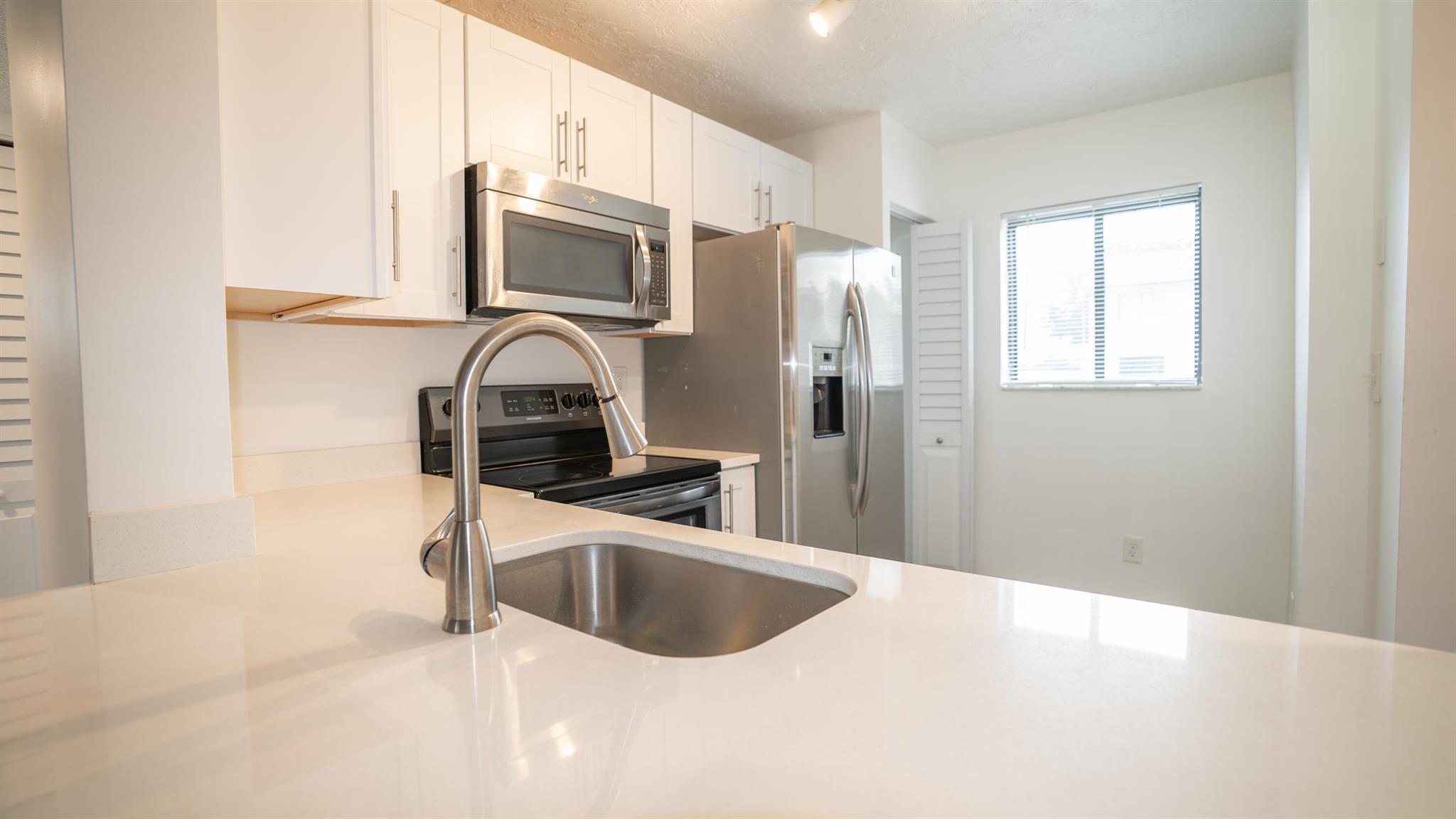 Don't miss your opportunity to live in a beautifully remodeled 2/2 CORNER UNIT on the first floor! This condo features waterproof laminate flooring throughout the unit, updated modern kitchen & bathrooms with a washer/dryer inside the unit! Enjoy your early morning coffee on your screened in back patio with convenient access to the community pool. Malibu Condo Community is centrally located to many restaurant's, shopping & highways! Water/trash included in the rent.