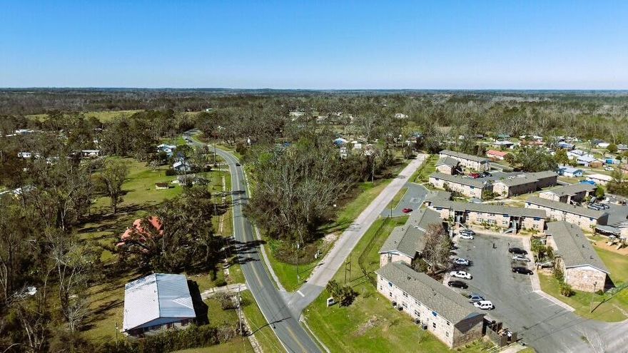 This centrally located, high and dry 1.74-acre lot in Madison offers a fantastic opportunity. It is a non-HOA, virgin wooded lot situated between two main roads, providing paved road access from SW MLK Jr. Dr and SW Bum Gardener Dr. Zoned R2, this parcel permits the construction of various types of residences, including conventional single-family homes, duplexes, multi-family units, tiny homes, or short-term vacation rentals. Notably, there is no minimum dwelling size specified in the city code. Utilities are available in the area; please call the City of Madison Utility for connection details and fee information. Tallahassee, the closest major city, is just 58 minutes away. Nearby attractions include Madison Blue Spring State Park & Falmouth Springs. Owner financing available for up to 72 months.