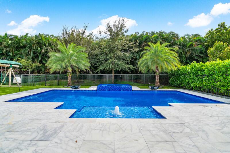 Move-in ready & highly updated 5 bedroom plus loft, 7 bathroom single family home w/ two car garage in the luxury community of Lotus of Boca Raton. Built in 2020, this Polynesia model home features over $400,000 in custom upgrades. Beautiful porcelain tile throughout first floor, chef's kitchen w/ large island, updated bathrooms, built-in bar area, custom closets, stunning stone accent wall, high end fixtures, central vac, full home generator, gorgeous backyard w/ sandblasted marble pavers & a heated salt water pool & spa, & the list goes on. The stunning home is situated on an oversized nearly quarter acre fully fenced lot w/ lots of private greenspace that has been professionally turfed. Lotus is a premier gated community in Boca Raton zoned for A rated schools w/ first class amenities.