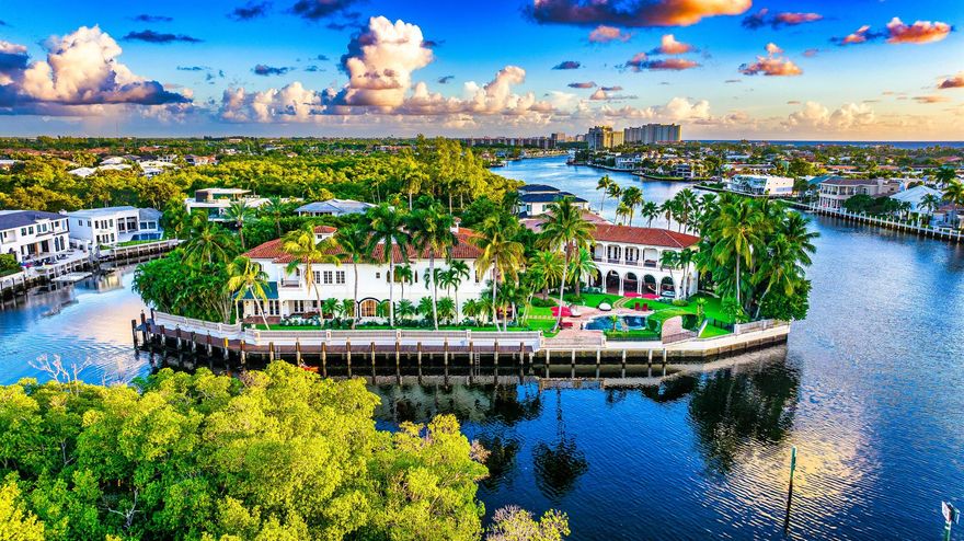 A Palm Beach-inspired Italianate masterwork, this Intracoastal trophy point estate commands 3.25+/- southeast-facing lots surrounded by 560+/- feet of stunning deepwater shoreline with multi-yacht Dockage.  In a tropical island atmosphere swathed with formal gardens, an expansive waterfront entertaining area offers resort-style living at its finest.  The magnificent  Pool is framed by a Chicago brick terrace.  Grand Loggias with pecky cypress ceilings incorporate the ground level of the Guest House providing a fireplace, Summer Kitchen, full catering Kitchen, and Powder Room.