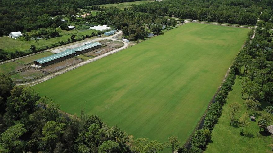 20 Acre Polo Farm, minutes from Wellington's Int'l Polo & Horse Shows venues. 12 ACRE POLO FIELD approx. 400'x 1235'.  installation supervised by Hugo Lloret, laser graded several times for footing perfection, the grass is TifTurf same as NPC fields. 2019- 40 stall center aisle barn. 2 tack rooms, 2 feed rooms, 4 wash racks, 7 paddocks, 3/2 mobile home for staff. This property is currently 2- 10 acre parcels including a unique 2 story 5/5.1 Pool Home, large bedrooms, plenty of bathrooms, impressive 20' ceilings and 2nd story huge loft for play room/office/ art studio & additional attic space. Enjoy the fruit of the mature exotic trees on property, lychees, longan, carambola etc. The equestrian possibilities are endless as this property can support many equestrian disciplines.