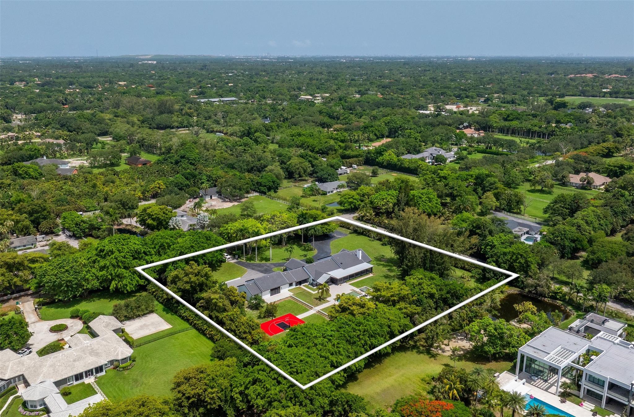 Welcome to an elegant sanctuary where design, privacy, and lifestyle unite in perfect harmony. Set on nearly 3 acres, this fully renovated estate—styled with Restoration Hardware finishes—features 5 bedrooms, 4.5 baths, and a flowing open-concept layout. Extensive upgrades include new roofing, full rewire with LED and Cat5/6, whole-home audio, a custom home theater, smart gate system, new kitchen and baths, decorative ceilings, and 4,000 SF of pavers. Outdoors, enjoy a resort-style pool, basketball court, two outdoor bars with pergolas, lush landscaping, and a 2,100-SF garage. Additional highlights include smart home integration, custom closet systems, enhanced insulation for year-round efficiency, and a serene screened porch. Sophisticated, smart, and truly turnkey.