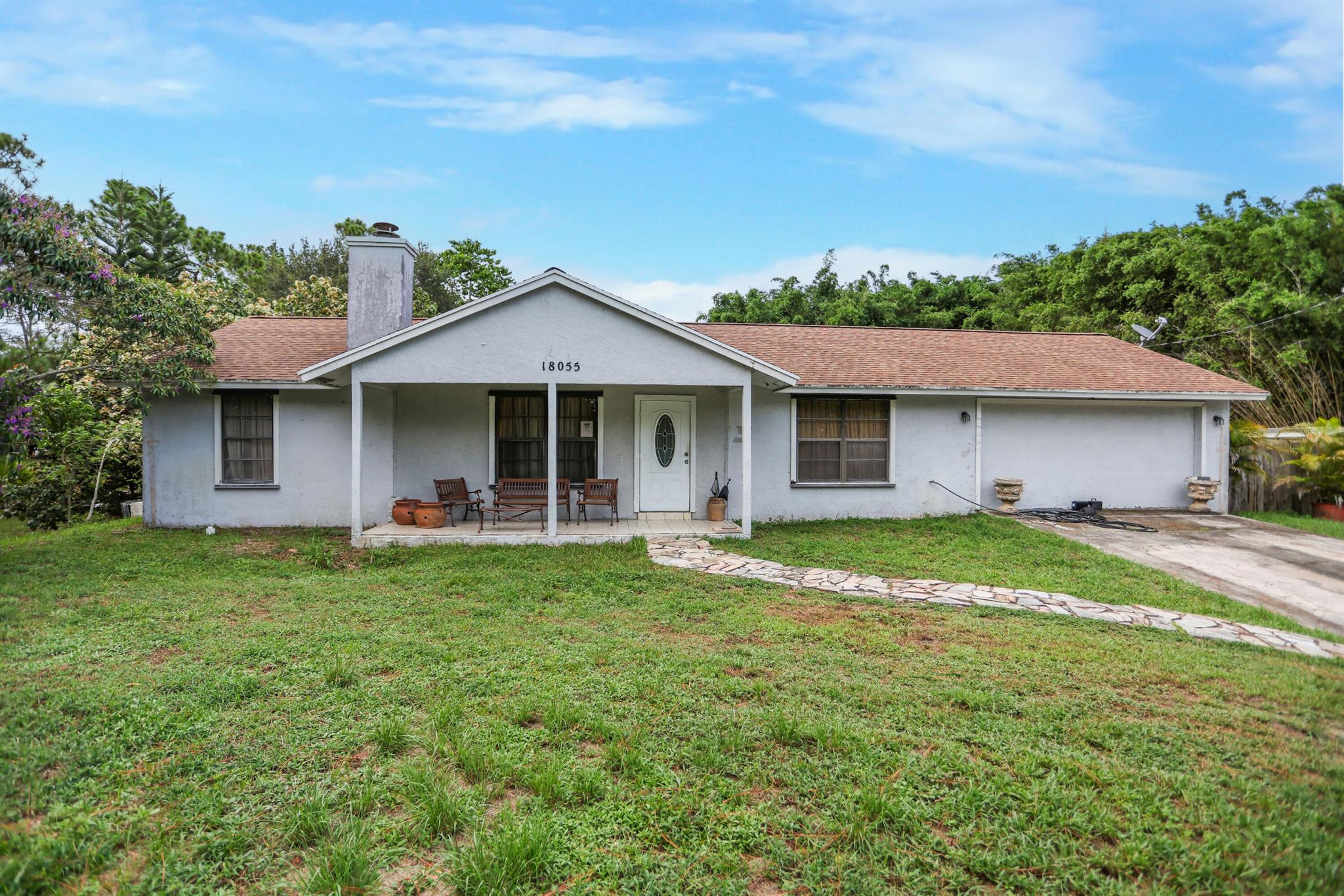 Welcome to 18055 W Sycamore Dr in beautiful Loxahatchee, just minutes from the growing community of Westlake! This charming 3-bedroom, 2-bathroom home offers over an acre of land, providing the perfect canvas for your dream home. Updated roof in 2020. Inside, you'll find a spacious layout full of possibilities, with generously sized bedrooms, a split floor plan, and ample natural light throughout. While the home is in need of updating, it presents a rare opportunity for customization and value-add improvements--ideal for investors, renovators, or anyone looking to create a personalized retreat in a peaceful, no-HOA neighborhood.