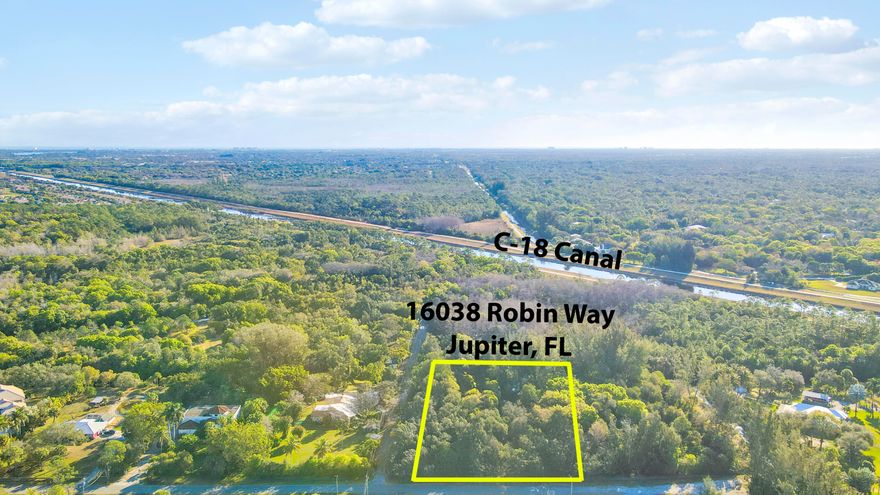Jupiter Farms 1.19 acres on paved road. Lush tropical vegetation with excellent elevation. Canal access to River Bend Park.
Rare Lot for sale in Jupiter Farms.
This is one of but a few remaining buildable lots currently for sale on Canal 14 in Jupiter Farms Florida. Located at 16038 Robin Way, the 1.19 acre property has 170 feet of frontage on a waterway feeding directly into the northwest fork of the Loxahatchee River. The river, described as ''one of the last two wild and scenic rivers remaining in Florida'', passes through Jonathan Dickinson State Park before emptying into the Jupiter Inlet and eventually the Atlantic Ocean. Since being purchased in  2000, the lot has seen twenty six years of continuous planting of tropical plants resulting in creating a subtropical rainforest with giant Kapok Monkey Pod, African Tulip, and a variety of huge Banyan trees to name but a few. A variety of palms, both native and nonnative together with giant bamboo are scattered throughout the property.The waterway bordering the back of the lot is home to alligator, manatee, otter, etc. As part of the greater Loxahatchee River Watershed, the waterway is popular for canoeing and kayaking. Riverbend and Loxahatchee River Battlefield Park borders the other side of the canal and offers hiking, biking, and horseback riding trails and the assurance that no homes or development will occur  on that side of the waterway. On secluded end of street abutting another vacant lot with million dollar properties nearby, the lot offers privacy and solitude in a tropical garden setting.