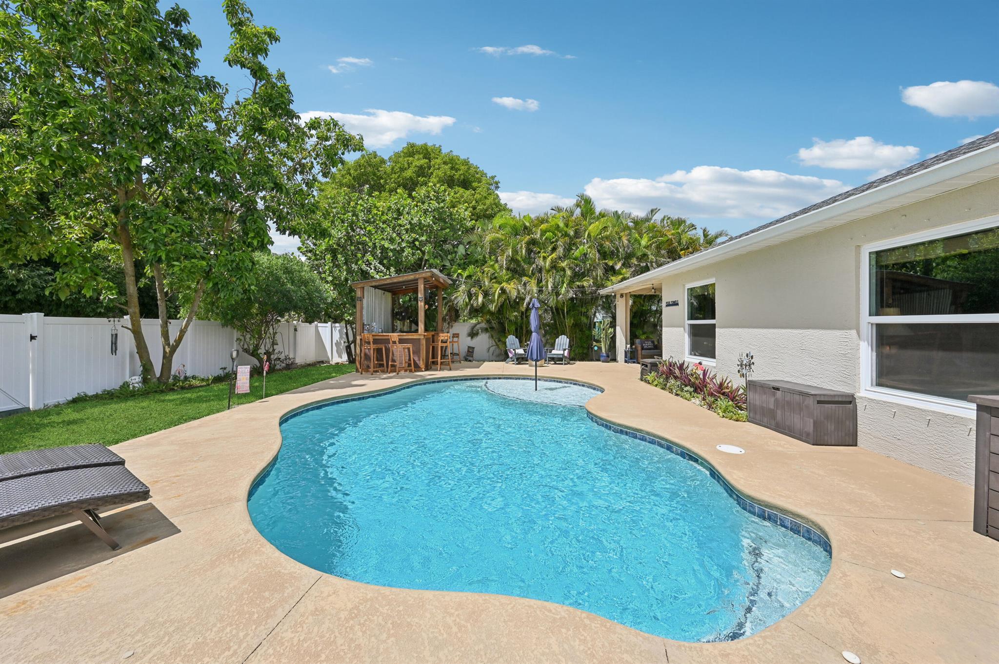 Port St. Lucie Saltwater Pool Home in No HOA Neighborhood | Easy Access to I-95 & Turnpike. This CBS-built home offers nearly 2,000 sq ft of living space with modern updates, including a new roof (2022), energy-efficient windows (2021), and a Rheem 4-ton A/C (2025). The open-concept Living, Dining, and Kitchen areas highlight views of the sparkling saltwater pool (2021)--the centerpiece of a true backyard retreat. A new vinyl privacy fence (2024) surrounds the outdoor oasis, complete with a spacious covered patio, lounge seating, full bar, and cooking station--perfect for poolside entertaining and Florida sunsets. Inside, the split floor plan features a Primary Suite with two walk-in closets, while a dedicated laundry room, kitchen pantry, and garage storage add convenience.