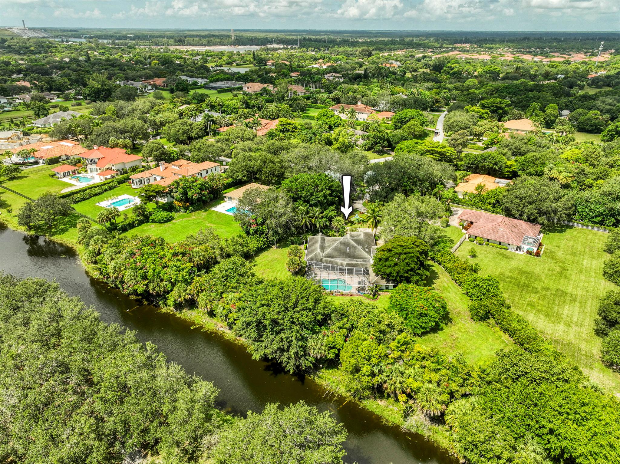 Nestled on a sprawling 1.24-acre cul-de-sac lot within the prestigious guard-gated community of Steeplechase in Palm Beach Gardens, this 4-bedroom, 3.5-bathroom estate offers both privacy and space to create your dream home. With 3,350 square feet of living area, a 3-car garage, and a screen-enclosed pool and patio overlooking a tranquil interior canal, this residence captures the essence of Florida living. Inside, the heart of the home is the kitchen, appointed with custom ecru-toned cabinetry, granite countertops and backsplash, stainless steel appliances, and a cozy breakfast nook set in a bay window with pool views. The adjoining family room, dining room, and living spaces are designed for connection, each offering French or sliding door access to the outdoor retreat and 180-degree