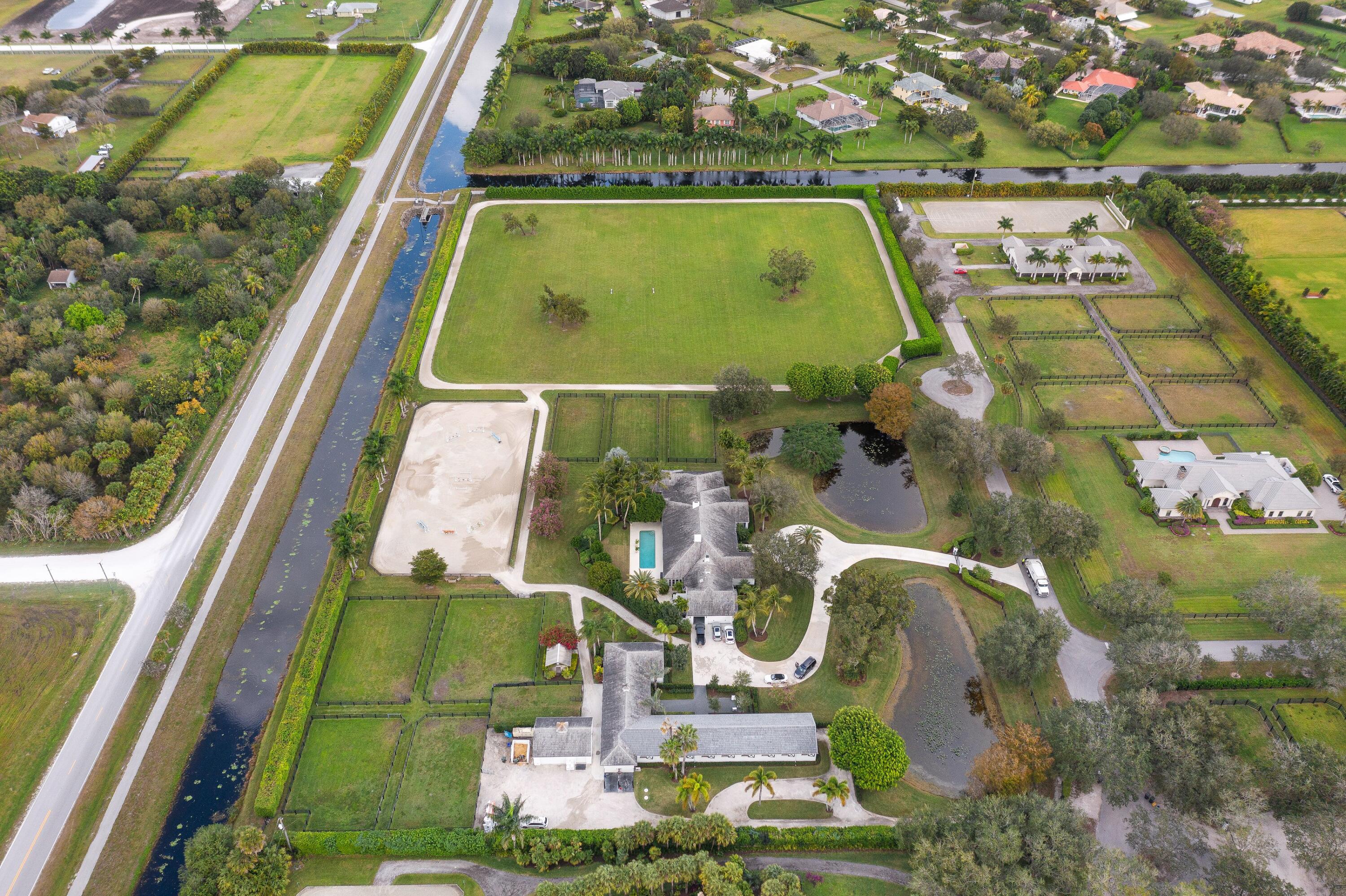Magnificent 10-acre farm on the most private & prestigious street in Palm Beach Point. Located at the end of the cul-de-sac, this classic equestrian estate has recently been renovated & is move-in ready. Enjoy the sunsets from either the beautiful & spacious living room or outside on the patio or pool area.With one push of a button, the patio becomes a screened-in loggia. Fireplaces in both the living room & family room warm this house up on the occasional cool winter season nights with options for formal dining or more casual get-togethers. The spacious family room & cooks dream of a kitchen make entertaining a breeze. Oversized primary & guests bedrooms & bathrooms. Superb game room/tv room. 12-stall barn w/ staff living & storage. New Wordley-Martin ring, Grand Prix Field & track.