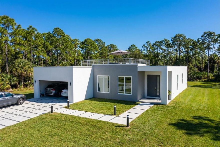 Modern new construction pre-manufactured home currently under development and scheduled for completion in the coming months. This thoughtfully designed residence features clean architectural lines, open living spaces, and large windows that bring in plenty of natural light. The open layout includes a contemporary kitchen with quality cabinetry, quartz countertops, and a central island connecting to the living and dining areas. The primary bedroom includes a private bathroom with modern fixtures and a glass-enclosed shower. Additional bedrooms provide flexible space for family living, children's rooms, guest space, or a home office. Sliding glass doors connect the interior living area to the outdoor space. Buyers who go under contract prior to completion may have the opportunity to select