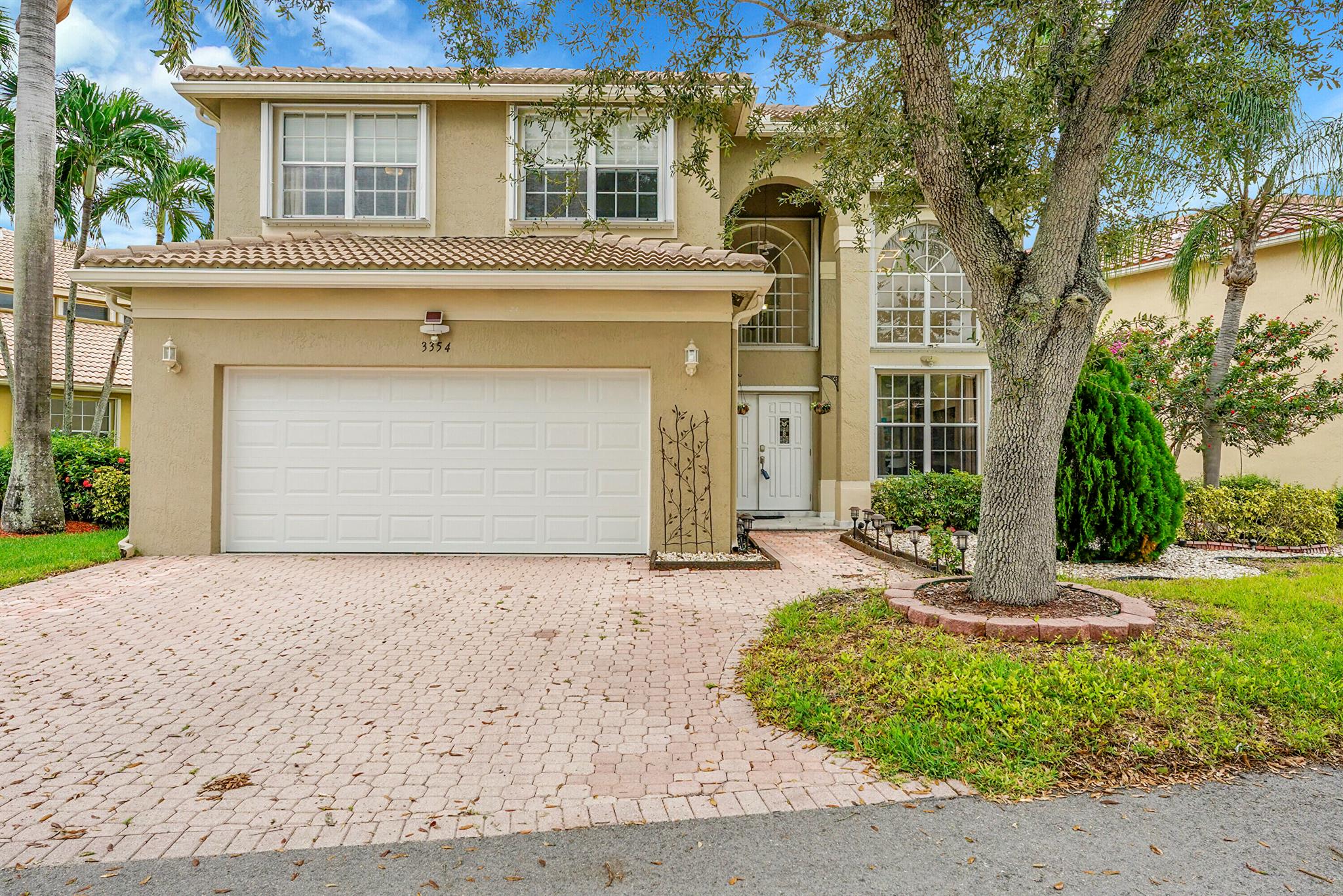 Spacious 4BR, 2.5BA home with 2,226 sq ft. & a 2 car garage with a Tesla charging station! Located in a gated community near shopping & highways. Enjoy peace of mind with a 2021 roof, new 5 ton A/C, and complete accordion shutters. Interior features stunning new luxury waterproof vinyl flooring throughout. New stainless appliances, granite countertops in kitchen, newer impact garage door & impact sliders going to the patio. Half bath downstairs was updated with a floating vanity & LED mirror. Relax in the screened patio-marble floors on the back patio & front patio. Pick fresh fruit from your own fenched backyard with many fruit trees. Perfect blend of comfort, convenience, and security--ideal for modern living!