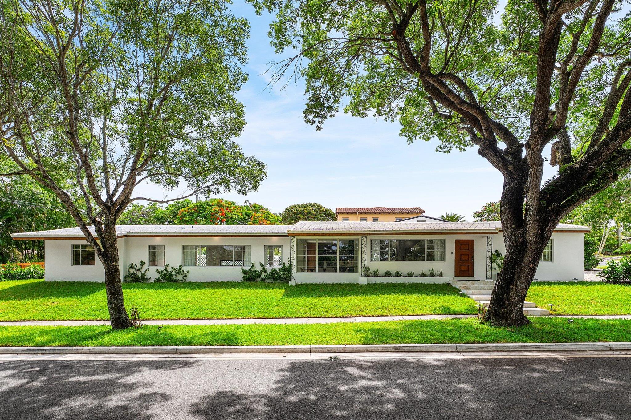 2330 Lake Avenue is a true showpiece--reimagined in 2025 by award-winning Flamingo Park Development and thoughtfully crafted to stand apart in one of West Palm Beach's most beloved historic neighborhoods.Behind its timeless facade lies a fully transformed single-story home offering 4 bedrooms, 3.5 bathrooms, a brand-new addition and pool, and design-forward interior--all within minutes from Downtown West Palm Beach and Palm Beach Island.This home blends historic character with a modern edge. Oversized 4' x 4' porcelain tile flooring sets the tone for the custom interior, where exposed ceiling beams, solid core wood doors, and clean-lined trim elevate the space.At the heart of the home is a dramatic dual-sided electric fireplace clad in quartz flagstone mosaic, accompanied