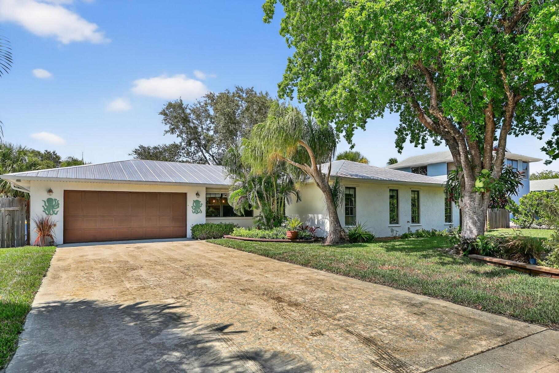 Coastal living at its best! Charming 3 BR | 2 BA | 2 Car Garage in the heart of Rocky Point with 1,924 sq ft of updated living space, this move-in-ready gem offers comfort, style, no HOA! Step inside to find wood-look tile flooring throughout & durable metal roof. Entertain in the Expansive kitchen, featuring ample countertops and cabinet space, SS appliances. Flexible floorplan: office/den, living room with cozy fireplace & built-ins (could be 4th BR), large family room. 22x11 screened porch opens to shady, fenced backyard. RV/Boat gated. Local marinas, Port Salerno waterfront dining, the public boat ramp. Maggy's Hammock Park, for birdwatching and hiking the Great Florida Birding Trail. Twin Rivers Park fishing, boardwalk strolls, & scenic views of the inlet. Full of Florida charm!