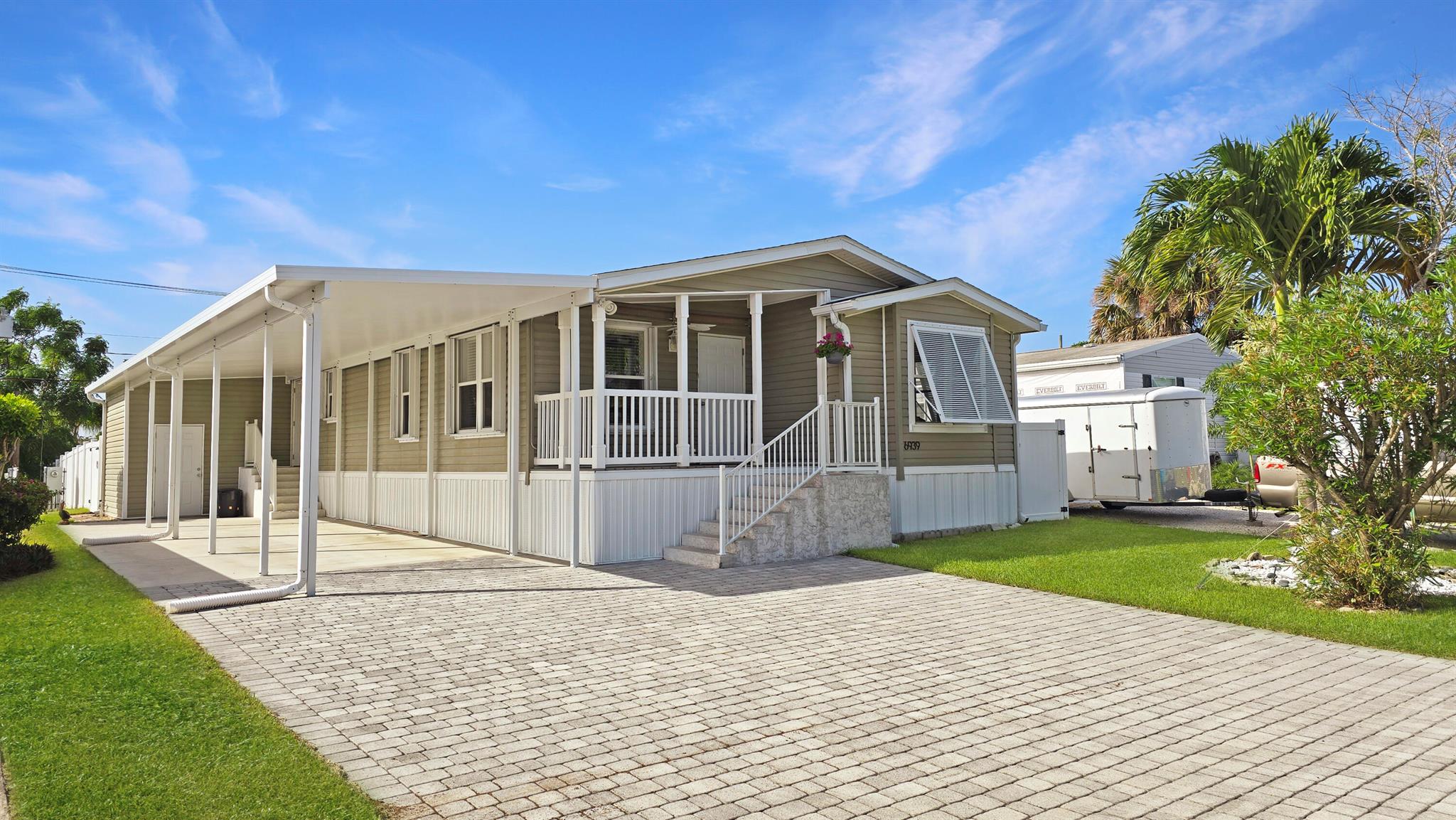 Perfect Beach Town Getaway. Upgraded 2017 Jacobson MANUFACTURED home w/1,550 SF of beautifully designed space along w/amazing exterior features. Granite & stainless appliance kitchen w/island, crown molding, seamless drywall, & custom closets. 2016 spa, 2021 infrared sauna, & large screened patio in a fully fenced backyard (6ft wht pvc privacy). 28ftx15ft screened patio w/electric, ceiling fan, & attached Elite Roof for plenty of shade. Built for comfort and durability with impact sliders/doors, hurricane shutters, 3/4'' plywood subfloor upgrade, storage & 2020 paver driveway. 48' Carport fits 2-3 vehicles. No HOA. Minutes to beaches, boat ramps, and all that Hobe Sound has to offer. Make this your beach getaway or become a first time homebuyer with this property that has it all!
