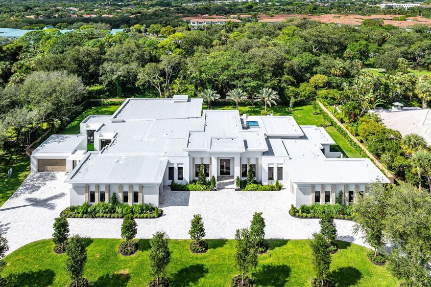 This sprawling NEW CONSTRUCTION estate is situated on one acre within the prestigious gated community of Foxe Chase, offering 12,500 square feet under roof with approximately 8,000 square feet of meticulously designed living space under air and a 7-car garage capacity. A harmonious blend of architectural elegance, modern technology, and master craftsmanship, this custom-built residence represents the pinnacle of South Florida luxury living.
