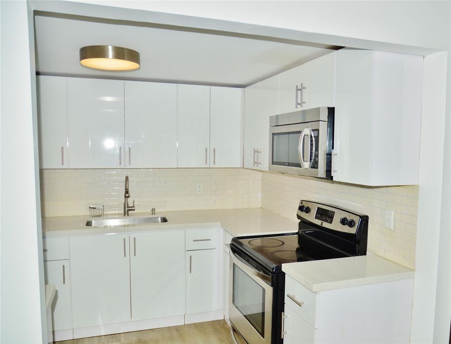 Located near the Turnpike and I95. Close to shopping and entertainment. This nice spacious 1 bed 1 bath condo has an updated kitchen with beautiful white cabinets/diamond-brite counter tops and stainless steel appliances. A cozy dining area just beyond the entrance, large living room, and laminate floors throughout. It has a South facing screened patio. The bedroom features a large walk in closet for wardrobe and a second closet for storage. There is additional storage for unit on ground floor. A brand new A/C unit replaced in 2024. Community pool and laundry room in complex. One assign parking space and guest parking.  If you are looking for a semi private community where you can relax and enjoy the surroundings come and check this one out.