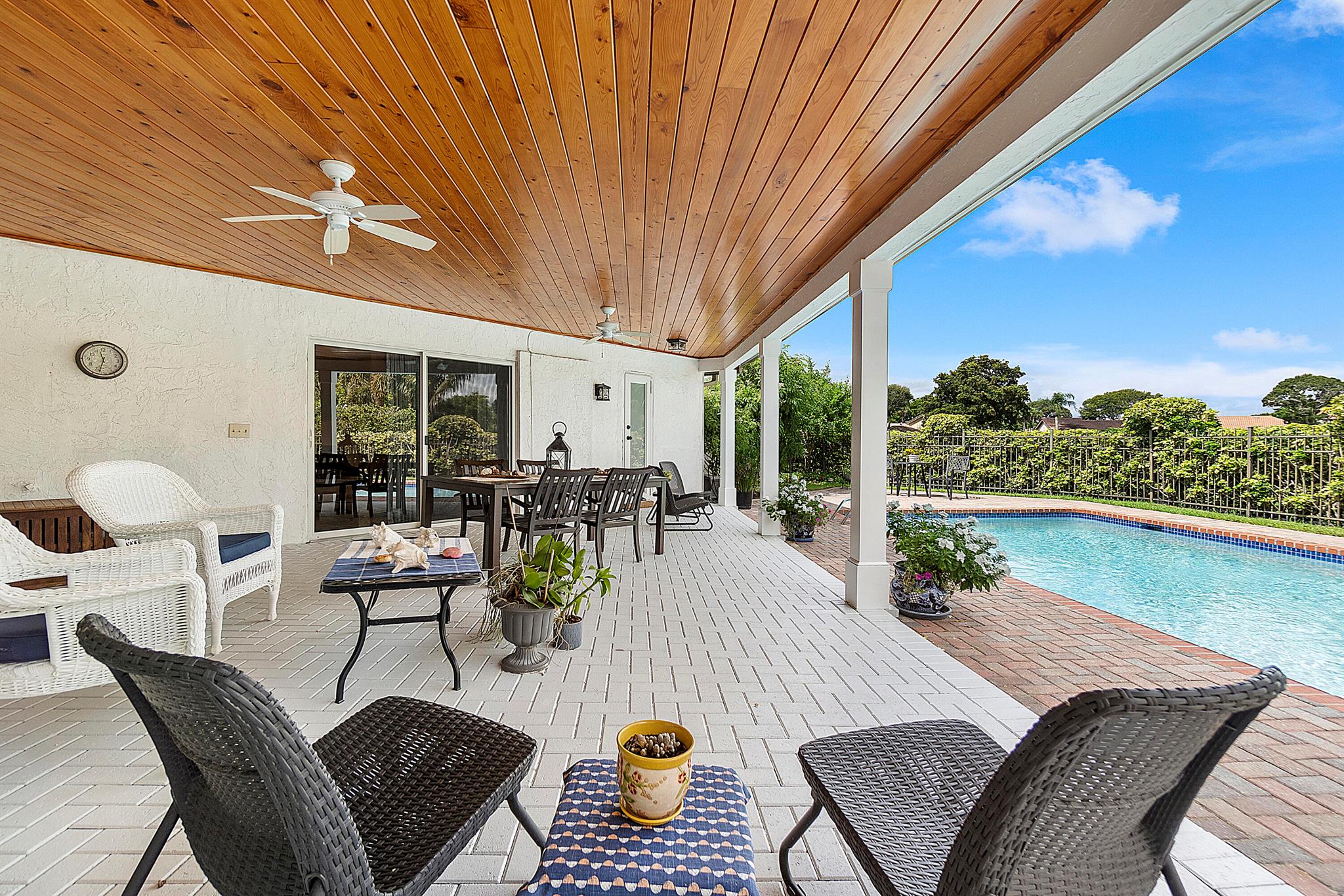 Beautiful residence surrounded by meticulous tropical landscaping, showcasing a sprawling yard adorned with a 15,000-gallon pool and an expansive brick paver patio overlooking serene Water & Golf course vistas--perfect for hosting gatherings. This 4-bedroom, 3-bathroom home features a grand entrance with glass door, marble tile flooring throughout the living areas, and elegant crown moldings & baseboards, complemented by impact glass windows and doors. The chef's kitchen, seamlessly connected to the family room, boasts upgraded cabinetry, stunning quartz counters, a glass tile backsplash, and top-of-the-line Stainless Steel appliances. The spacious primary bedroom offers dual walk-in closets and a bonus closet, along with a remodeled bathroom featuring a luxurious soaking tub and separate