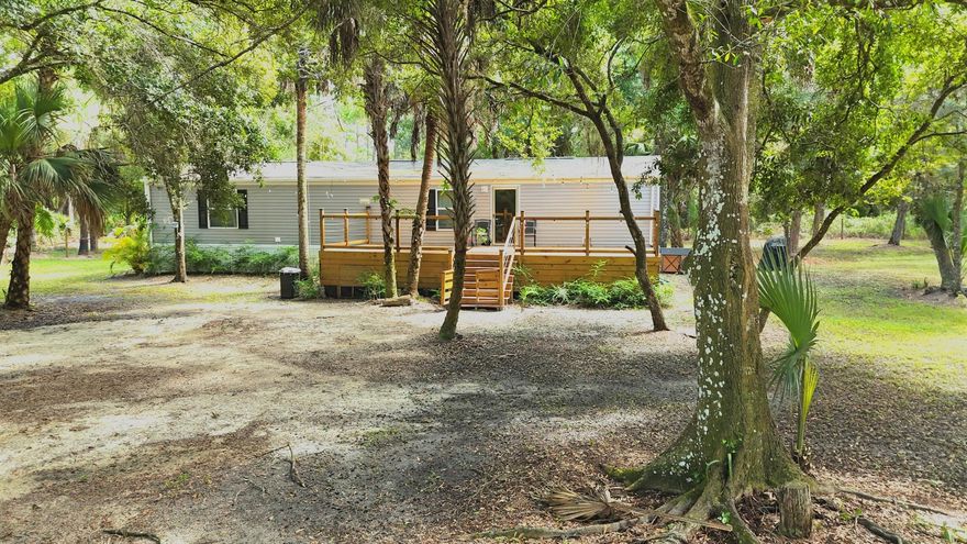 Discover this charming, almost brand-new manufactured home built in 2023 a true hidden gem surrounded by nature's beauty. This 2-bedroom, 2-bath single-wide home (840 sqft) offers modern appliances, new A/C, and two spacious decks extending your outdoor living area. Nestled on a lush 1.25-acre lot adorned with majestic native Florida cypress trees, the property provides a stunning natural landscape and a sense of peace, romance, and serenity.This property combines comfort and character, featuring two separate storage units; the larger one offers income potential, ideal to convert into an additional bedroom, guest suite, or home office. Zoned RRF (Residential Rural Farm) -- bring your farm animals, livestock, and personal crops to create your own sustainable oasis.
