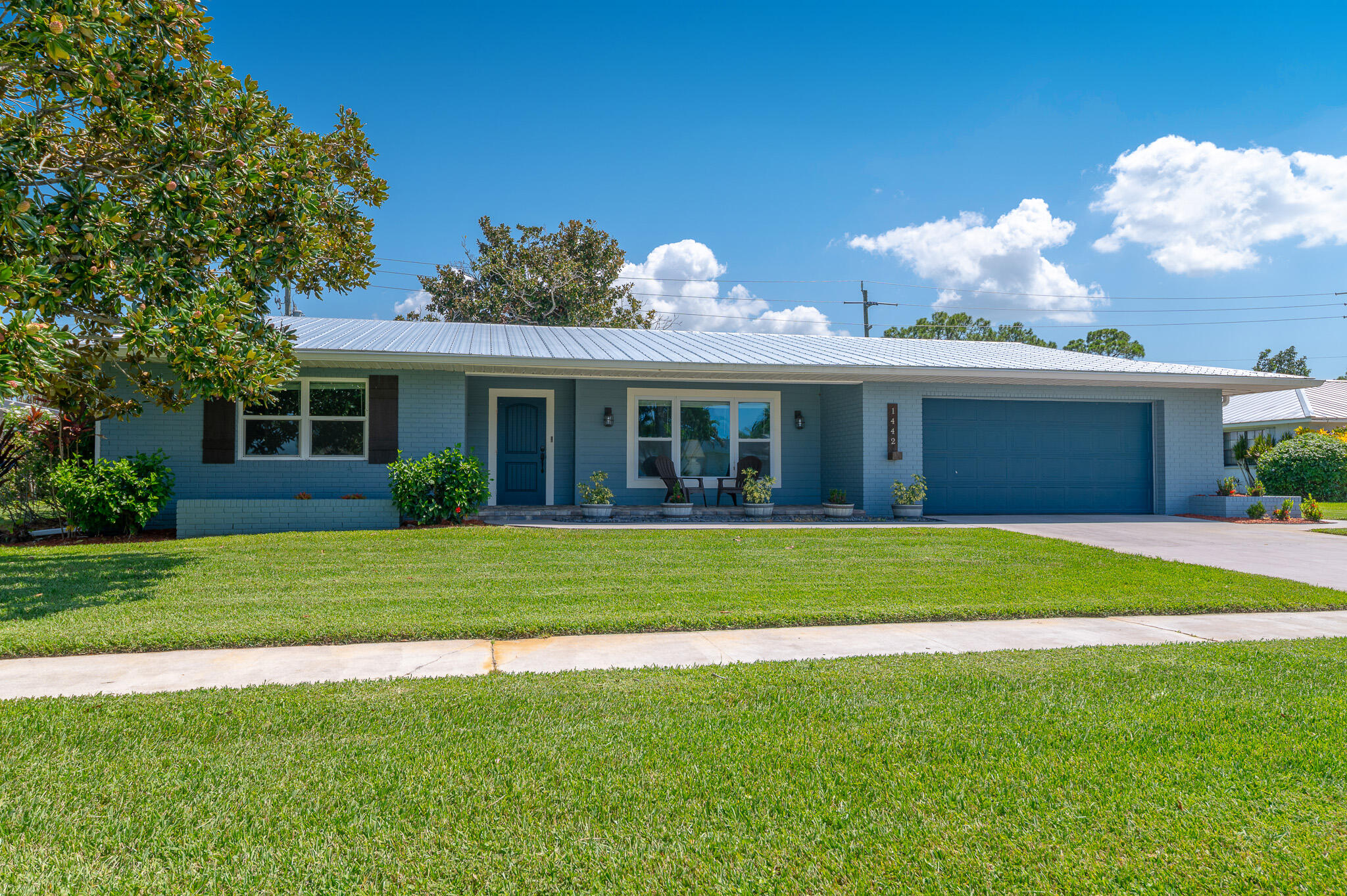 Welcome to this charming home with newer metal roof 2020, impact windows and doors 2019, tankless gas water heater 2020, A/C 2021, offering 4 bedrooms, 2 bathrooms and 2 car garage. Kitchen features white Shaker cabinets with quartz counters, gas range and a generous amount of counter space. Discover this home which is light and bright with an open concept offering an atmosphere of relaxation. Close to Shopping, beaches,
