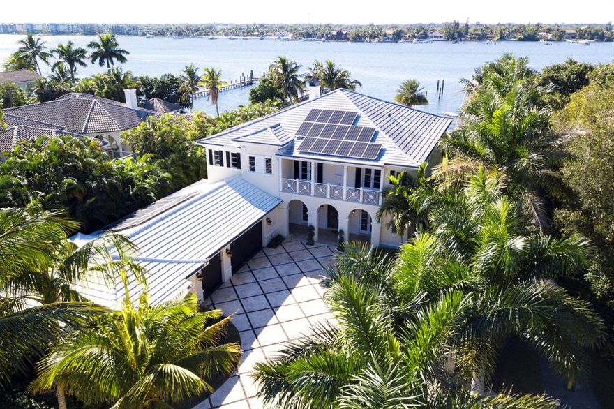 Spectacular custom built British West Indies Intracoastal Estate.  This four bedroom, four and one-half bath 9,291 SF home has top of the line finishes with special attention to detail, a three-car garage and guest house with self-contained living quarters.  Grounds feature sprawling water views with 102+/- feet of direct Intracoastal frontage, sparkling saltwater lap pool, two large covered patios for dining and living, fire pit, dock to accommodate a large boat, plenty of green space in both front and backyard and a very private walled and gated front yard.Enter the home through the covered entryway into a foyer peering out through two-story living room onto the Intracoastal Waterway.  To the North of the foyer is an elegant spacious dining room perfect for entertaining guests and