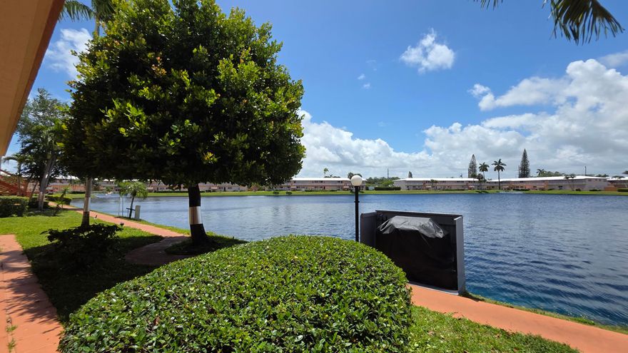 This lakefront unit in the Rolen Lakes 55+ co-op community offers a perfect blend of comfort and scenic beauty. Move-in ready and fully furnished, this 2-bedroom, 1-bathroom home is designed for easy South Florida living.  The interior features two split A/C systems for efficient cooling and is protected by impact windows and additional shutters for peace of mind.  Enjoy stunning western exposures from your back porch, providing front-row seats to vibrant evening sunsets. A magnificent mature tree sits just off the porch, offering natural shade that keeps the outdoor living space cool and inviting.  Convenience is key: the unit is located steps away from the community BBQ area and laundry facilities. Experience a relaxed lifestyle in a prime lakefront location.