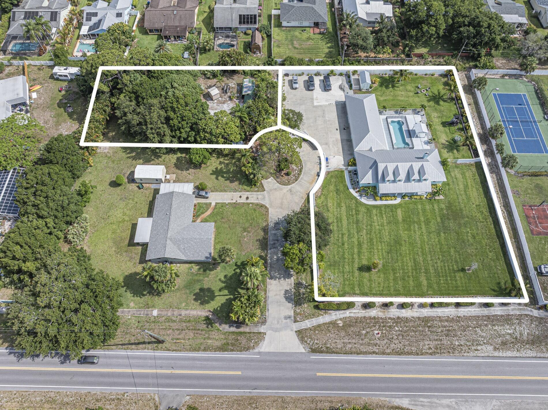 Total 1.42 Acres! Great Location. Minutes from the Beach. Property has concrete perimeter wall w/ entry gate on large driveway adding privacy & security. Engineered plans included for Shop/Guest House build on adjacent half acre lot, $8k value. Attached garage is converted to guest apartment. Large attic for storage. 2016 concrete block w/ metal roof & impact windows offers low insurance & peace of mind. Pool w/ salt system & new heater chiller. Amazing property with endless possibilities.