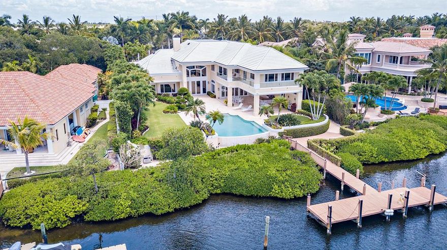 Rare opportunity to live on the most sought-after street of Spyglass court in the exclusive community of Admirals Cove. Expansive 28,749 +/- sq ft lot with 102' of water frontage facing a barrier island. Entering this 9,290 SqFt masterpiece with dramatic open spaces and soaring ceilings offers water views from almost every room. Lavish master suite with newly renovated master bathroom. The resort style backyard includes an expansive loggia and a new summer kitchen. This home is complete with all new kitchen appliances, a private guest suite with a kitchenette, a new roof and a full home generator. Boaters dream with a private dock, no fixed bridges and quick access to the ocean. Located close to the main club house. Required golf membership purchase conveys all the first-class amenities of