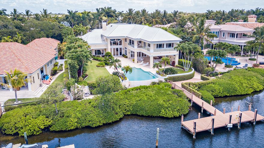 Rare opportunity to live on the most sought-after street of Spyglass court in the exclusive community of Admirals Cove. Expansive 28,749 +/- sq ft lot with 102' of water frontage facing a barrier island. Entering this 9,290 SqFt masterpiece with dramatic open spaces and soaring ceilings offers water views from almost every room. Lavish master suite with newly renovated master bathroom. The resort style backyard includes an expansive loggia and a new summer kitchen. This home is complete with all new kitchen appliances, a private guest suite with a kitchenette, a new roof and a full home generator. Boaters dream with a private dock, no fixed bridges and quick access to the ocean. Located close to the main club house. Required golf membership purchase conveys all the first-class amenities of Admirals Cove. AMENITIES: 45 holes of golf, 5 restaurants, 58 slip marina with floating docks, Yacht Club, har-tru tennis courts, pickleball courts, state-of-the-art fitness and wellness, 21,000 sq ft brand new spa & salon.