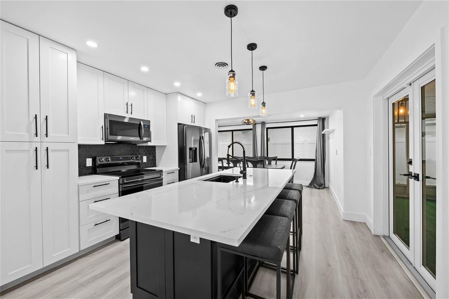 Beautifully updated 2BR/2BA corner home with covered carport and extensive 2025 upgrades, including a new roof being installed. Bright open living spaces with renovated kitchen and baths featuring quartz countertops, soft-close cabinetry, and pull-out pantry drawers. New Samsung stainless steel smart appliances, including a refrigerator, oven, microwave, and dishwasher. All Impact windows and ceiling fans in bedrooms. Enjoy indoor-outdoor living with a large screened-in patio and a Florida room perfect for an office, gym, or den. $27K plumbing upgrade to PVC, 200-amp electrical, new Rheem tankless water heater, indoor laundry, and private 6-ft vinyl fenced yard. Low HOA $90/mo covers lawn, sprinklers, pool, and clubhouse. Walk to the Caporella Park with a splash pad and an amphitheater