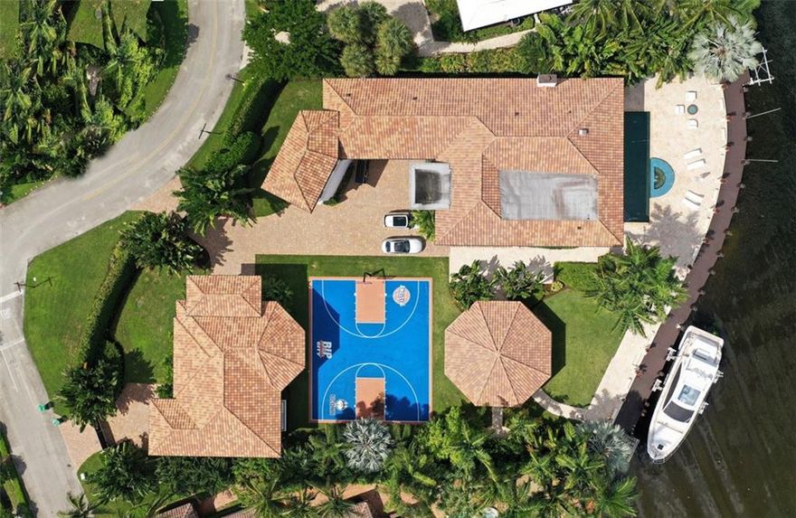 Elegance and glamour emanates from this masterful double lot Intracoastal Estate home in this private guard gated community with beach club. 171' cement dock with 2 lifts. Clean modern lines blend with delicate designs to create a stylish oasis of comfort and luxury. Main house features 2-story foyer with Chihuly chandelier & grand staircase adjacent executive office overlooking guest house, gazebo, basketball court. The home flows seamlessly from formal living to dining and bar area featuring fireplace, custom woodwork and lighting. Master Suite offers his and hers baths and closets plus sitting room/office. Infinity edge pool features fountains & hot tub. 1,000SF gazebo with massive glowing white glass bar. Magnificent guest house offers theater, game room, practice court, & guest suite. PROPERTY SITS ON A DOUBLE LOTS AND CAN BE DIVIDED INTO TWO LOTS WITHOUT AFFECTING THE EXISTING HOUSE.