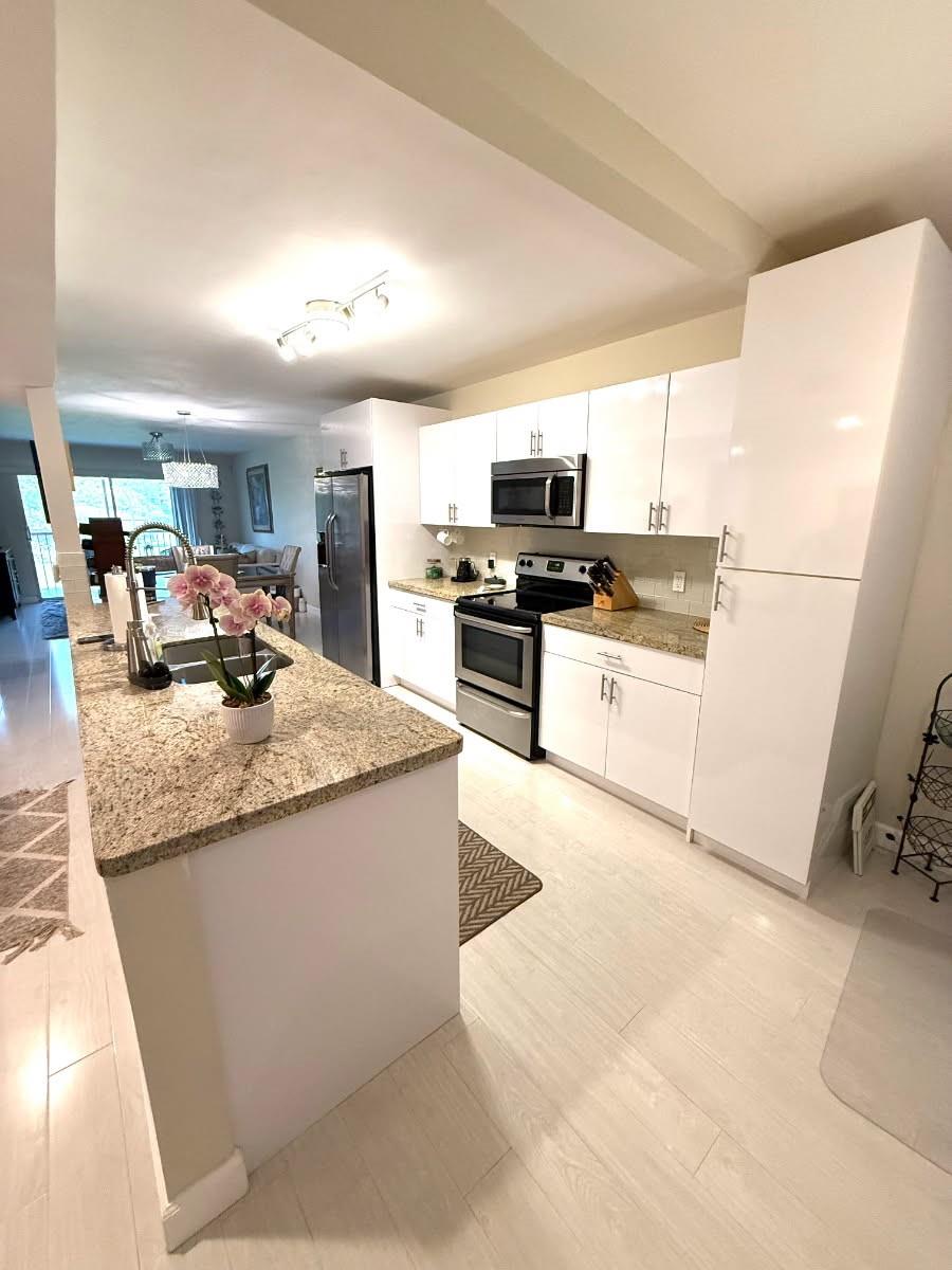 Just REDUCED! Welcome to this beautiful updated 2/2 condo in vibrant 55+ gated Century Village Community. This unit features a stunning Open eat in kitchen with white cabinets, pullouts, & granite, SS appliances, waterproof laminate wood flooring, & overlooking the pool. Each bedroom has a walk-in closet, washer & dryer in the unit, bathrooms remodeled, & Accordion shutters. Building is freshly painted, roof approx. 5 years old & no assessments. Very close to residential entrance on Pembroke RD. So many amenities in this resort style living including, golf, tennis, fitness center. 24-hour security, & a busy clubhouse with entertainment and social activities. Start your next chapter here, in a perfect place to call home! Nothing needs to be done to this condo!