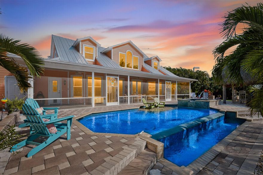 Discover the ultimate Florida lifestyle in this stunning waterfront home offering 250 feet of canal frontage just off the St. Lucie River with ocean access. Set on over a half acre on a quiet cul-de-sac, this 2 story home features a new metal roof (2023), complete impact glass, and a gorgeous infinity-edge pool with spa beside a tropical tiki hut. Enjoy a new seawall and composite dock (2024) with boat lift--perfect for effortless days on the water, sunset cruises, or weekend adventures. The wrap-around porch and expansive back patio create ideal spaces to relax and take in the water views. Inside, you'll find a stunning updated kitchen, renovated upstairs bath, loft space, plantation shutters, crown molding, and wood-look tile floors. Lush landscaping surrounds the home,