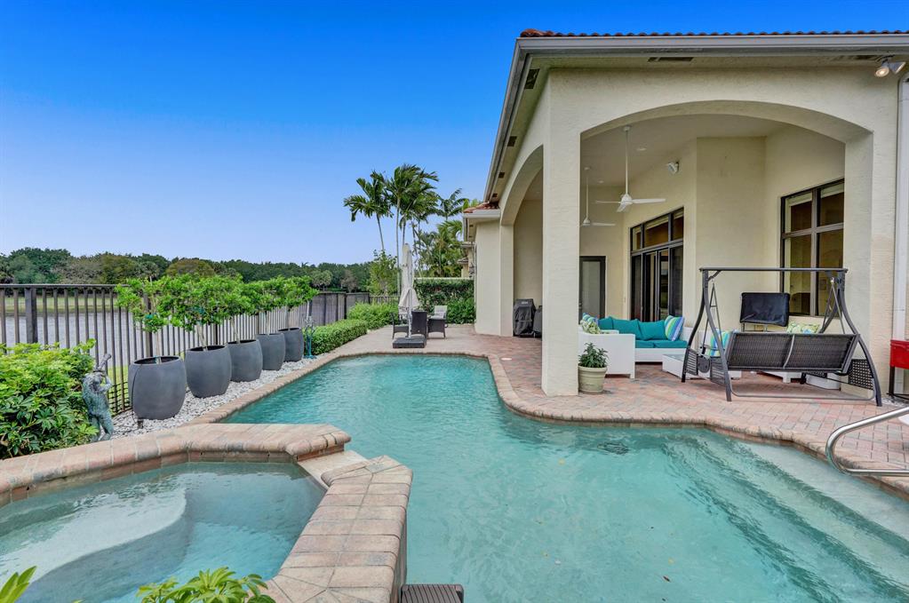 Move right into this meticulously maintained home. Click the virtual walk through and video. This magnificent residence is on a prime private lake lot and features 3 en-suite bedrooms plus an office/4th bedroom, all on one single level, w/ a triple-split floor plan. Highlights include marble floors thru-out the entire house, a gourmet chef's kitchen with a Thermador refrigerator, Viking 6 burner cooktop, and Miele double oven. Enjoy spectacular sunsets overlooking the lake and marshland that will impress. The patio features new landscaping, a natural gas grill and heated jacuzzi overflowing into your own private pool. The home has 3 new air conditioners, top of the line natural gas generator and full hurricane impact windows/doors. This home has been customized to your every comf