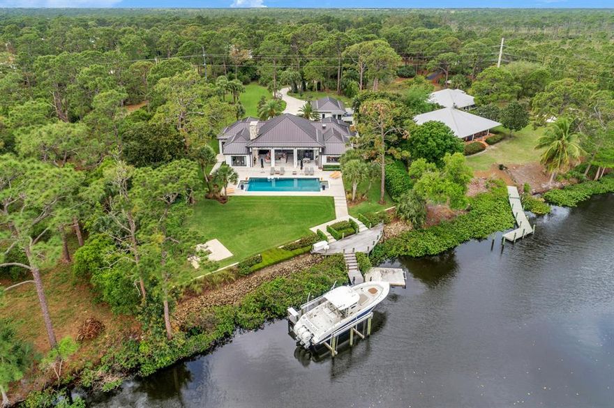 Magnificent Custom Home offers only the best! Best location on the Loxahatchee River with 127 feet of direct water frontage and a private dock with 20,000 lb lift. This gated West Indies design home is perfectly situated on 1.60 acres with unobstructed views of Jonathan Dickenson State Park. It features 4 bedrooms, 4 full baths, pool, and a detached 3 car garage. Construction upgrades include waterproof paint, Icynene insulation, hurricane rated windows and doors, mahogany French doors, 8 foot interior doors, summer kitchen, 3 car garage, Florida Coquina Stone sidewalks and porches, Peaky Cypress porch ceilings,